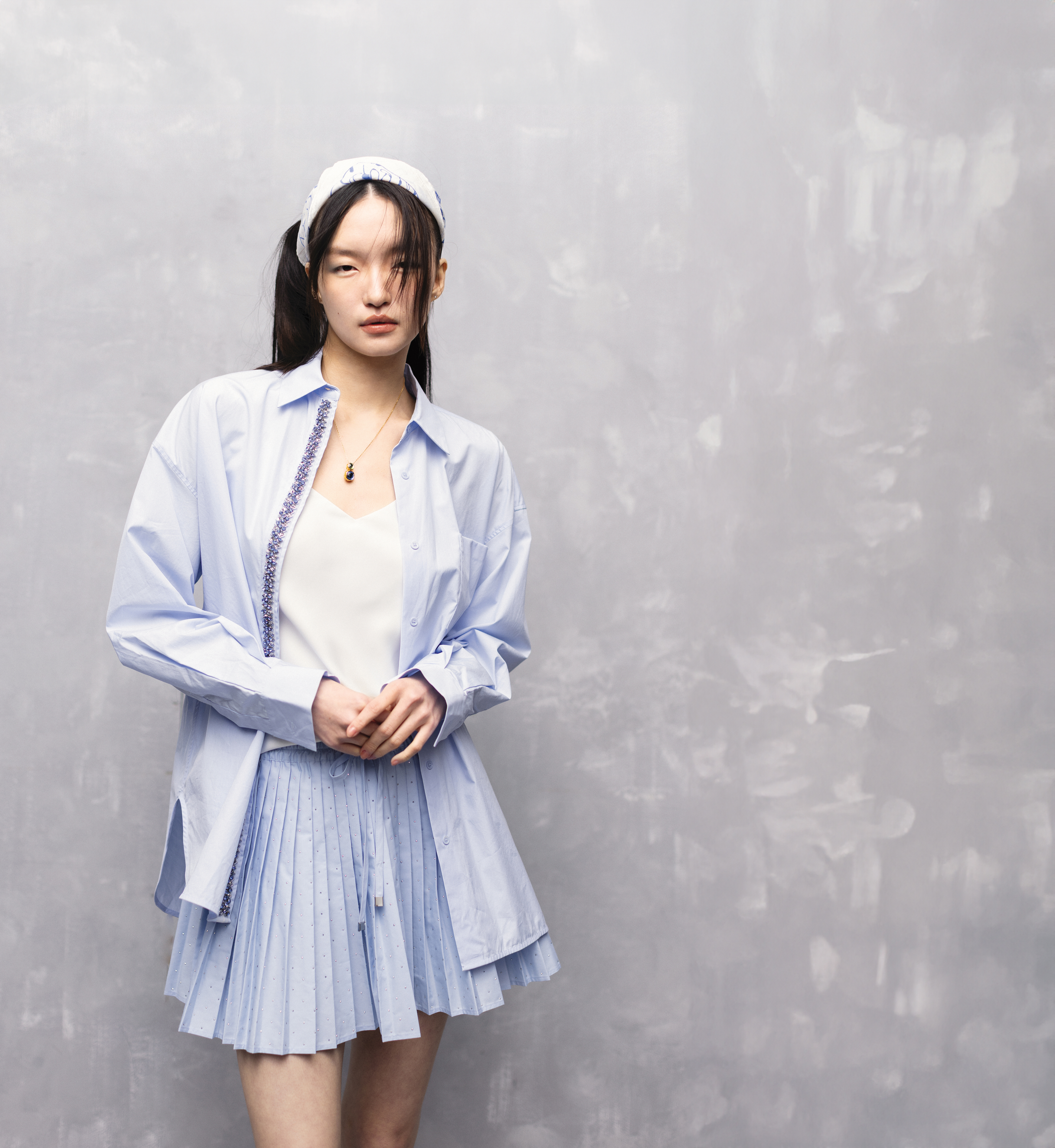 水鑽府綢襯衫 NT$10,790 by maje；細肩帶背心 NT$4,900 by CLUB MONACO；水藍色水鑽百褶裙 NT$7,690 by sandro；藝術家Petra Börner系列印花大方巾（作為髮帶） NT$7,490 by Marimekko；Chroma項鍊NT$6,300 by SWAROVSKI。