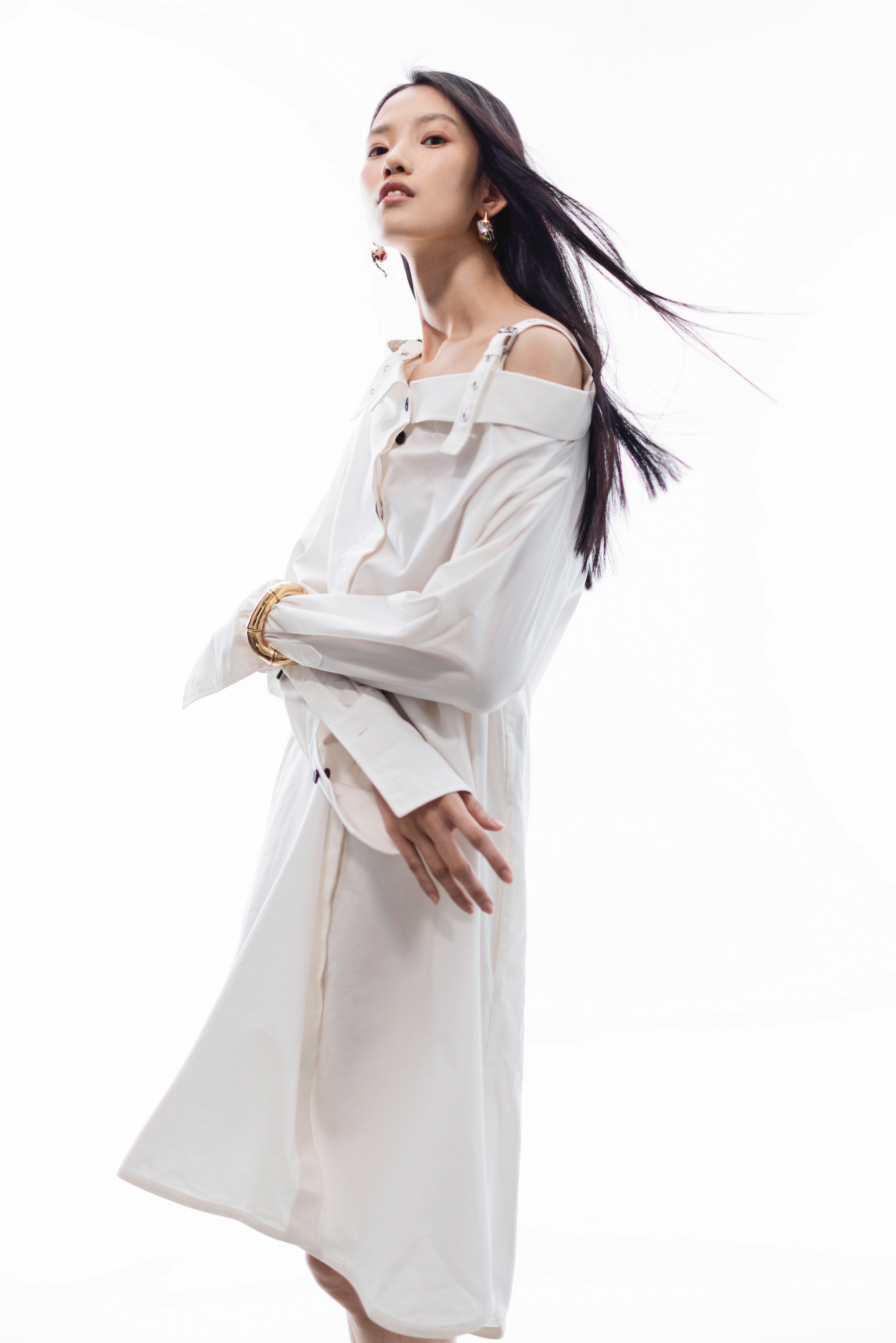 白色露肩襯衫洋裝 NT$130,000 by Dior／Rana珍珠青蛙耳環 NT$67,700 by BOTTEGA VENETA／金色竹節手環 價格店洽 by GUCCI