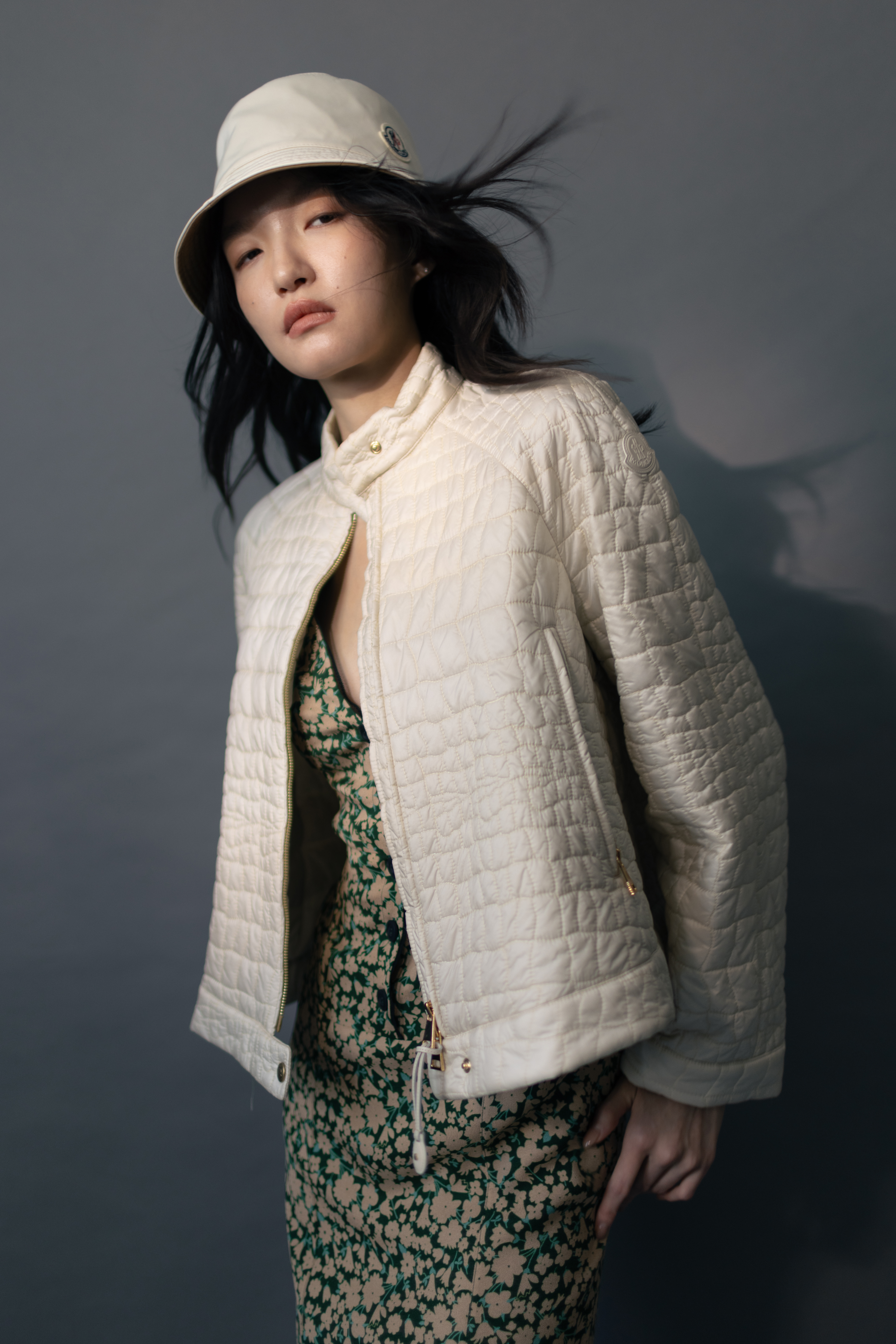 Aubrieta幾何絎縫短身羽絨外套 NT$59,100 by MONCLER／碎花洋裝 價格店洽 by PRADA／雙面漁夫帽 NT$19,000 by MONCLER