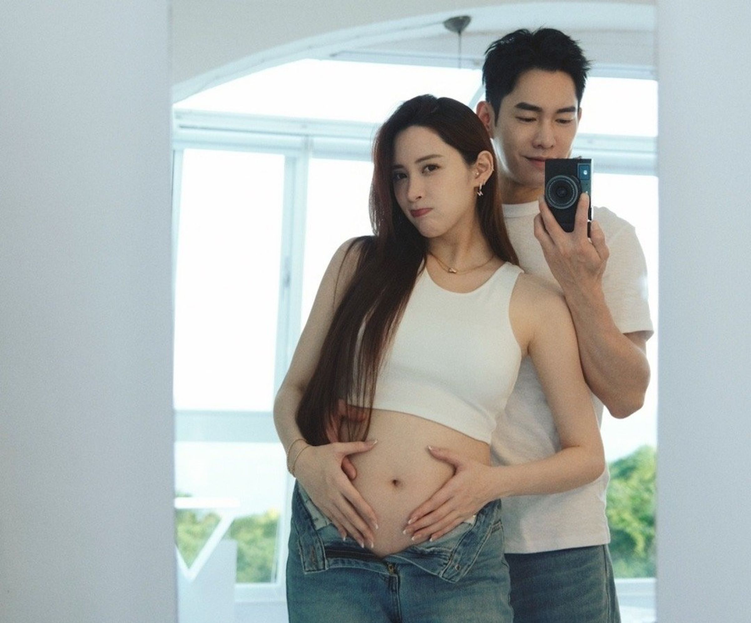 稍早歐陽妮妮PO出幾張合照,其中一張是張書豪在身後自拍,妮妮在前露出凸起的肚皮。(翻攝自歐陽妮妮微博)