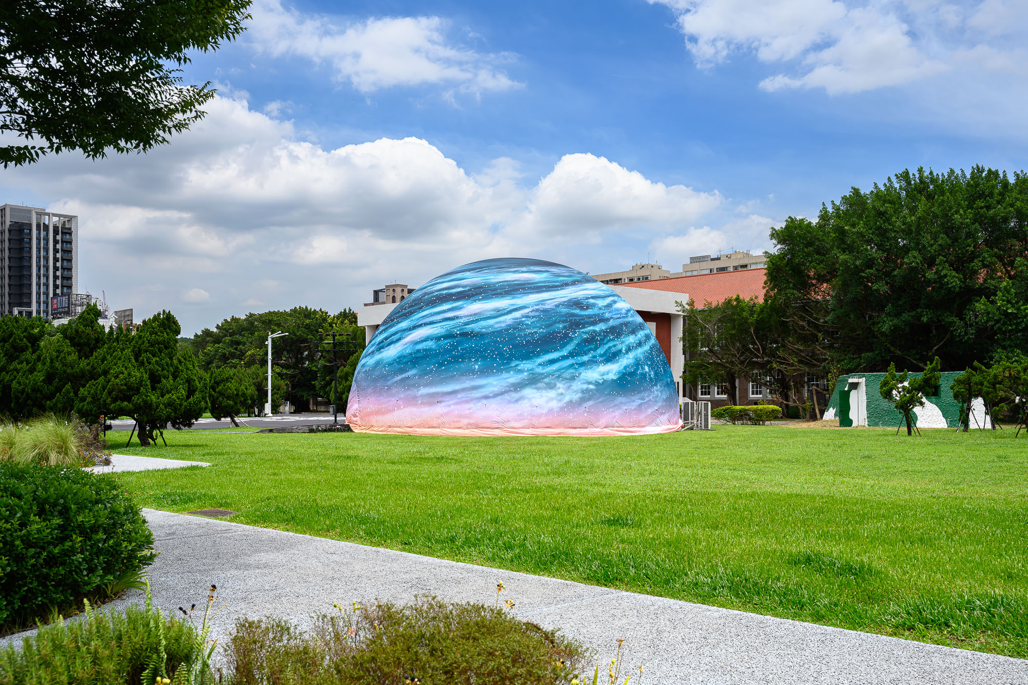 穹頂劇場外觀配合推出地景作品《晴穹:晴空下的破曉旭日》,將穹頂化為落地的天體,象徵開放天空與觀看想像的交會。(C-LAB提供/王世邦攝影)