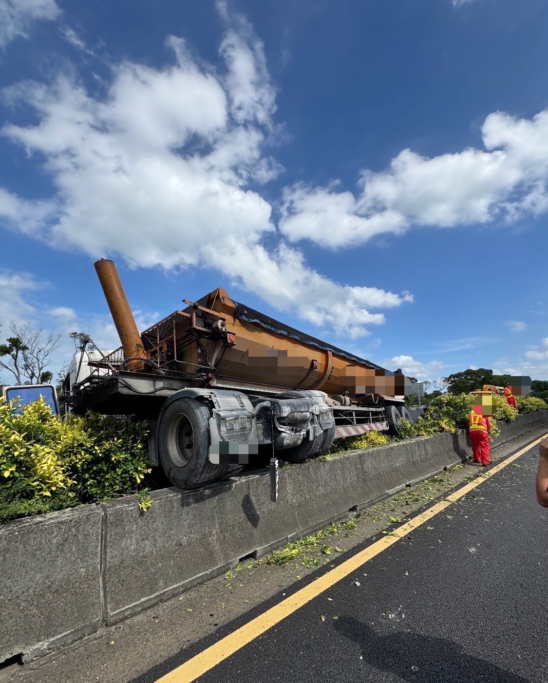 砂石車肇事後車體卡在中央分隔島上，導致南北向內側車流受阻。（翻攝畫面）