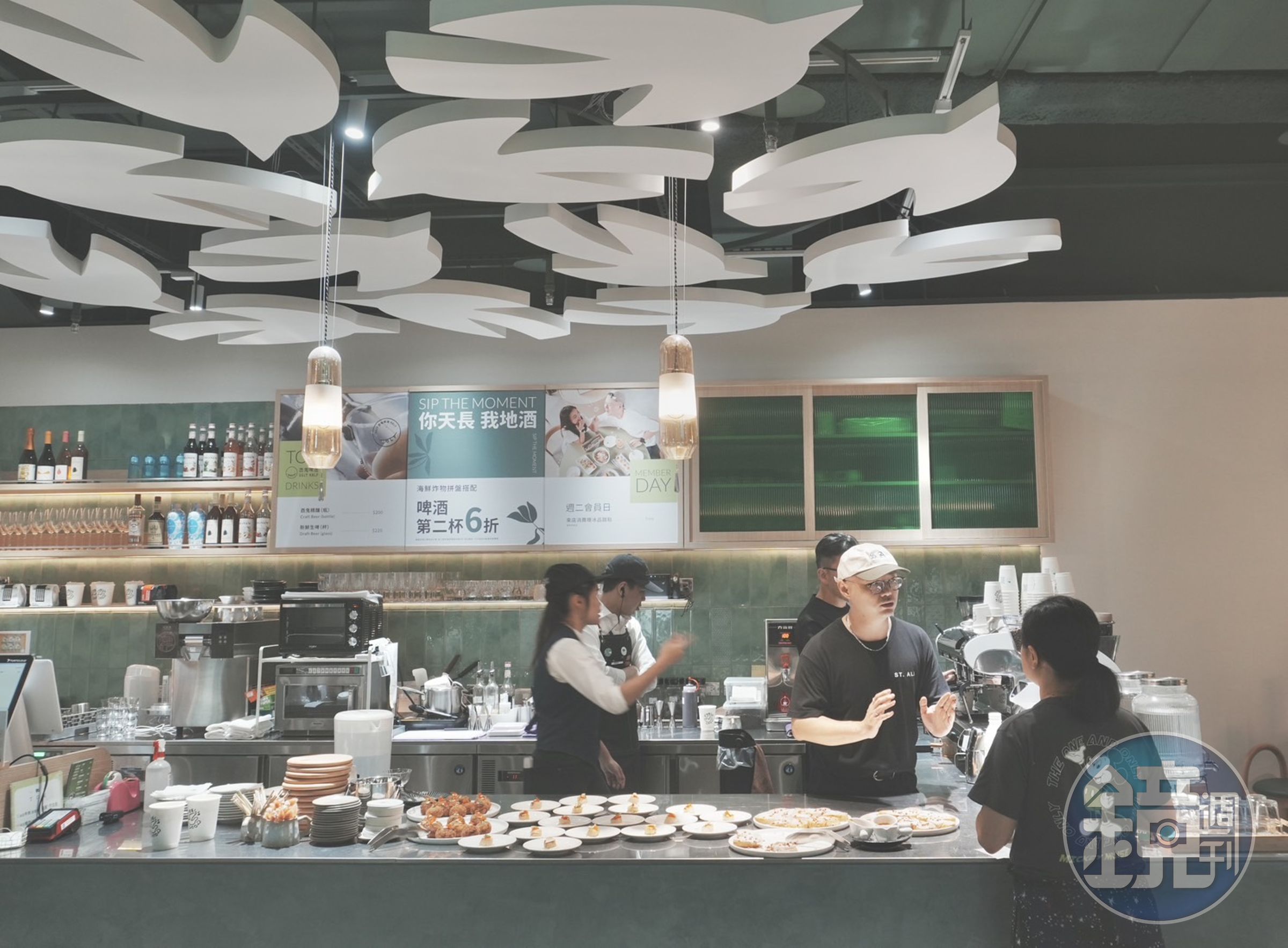 「TOK盡興食光」大巨蛋店於祖母綠磚吧檯上，設計成群盤旋的啄木鳥LOGO，為空間帶來更多生命力。