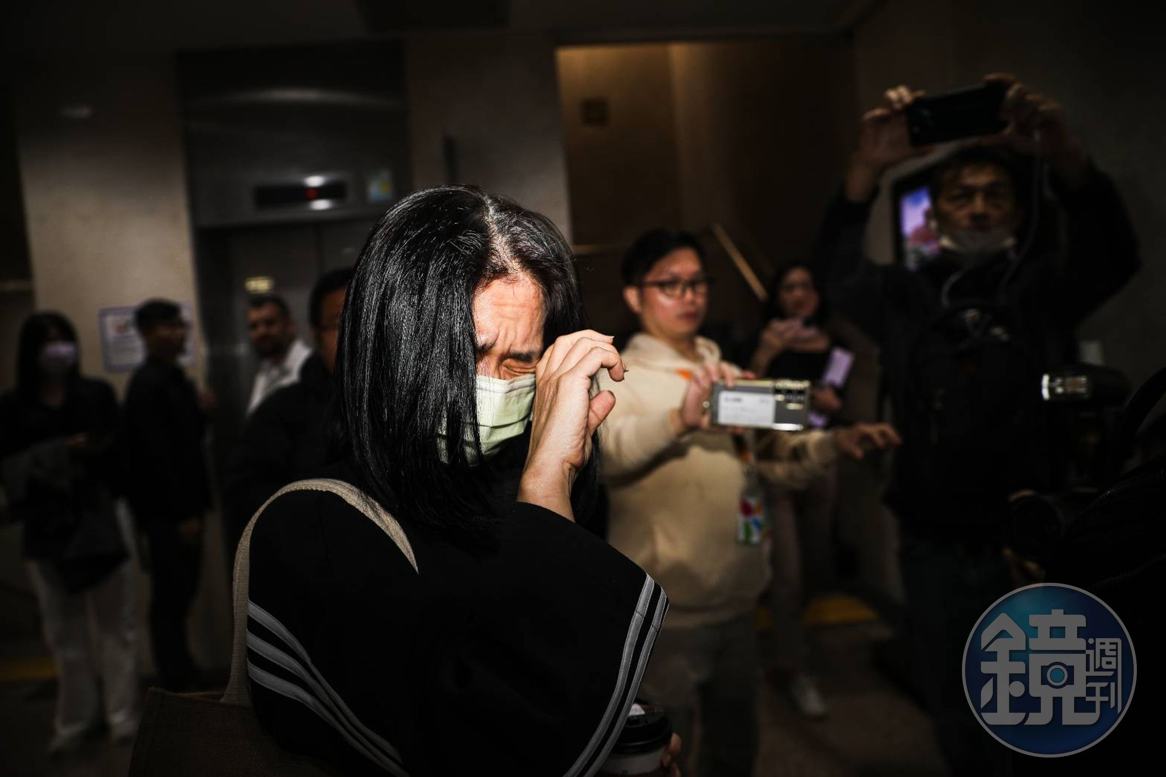 李文娟遭傳喚到案,面對鏡頭皺眉閉眼。