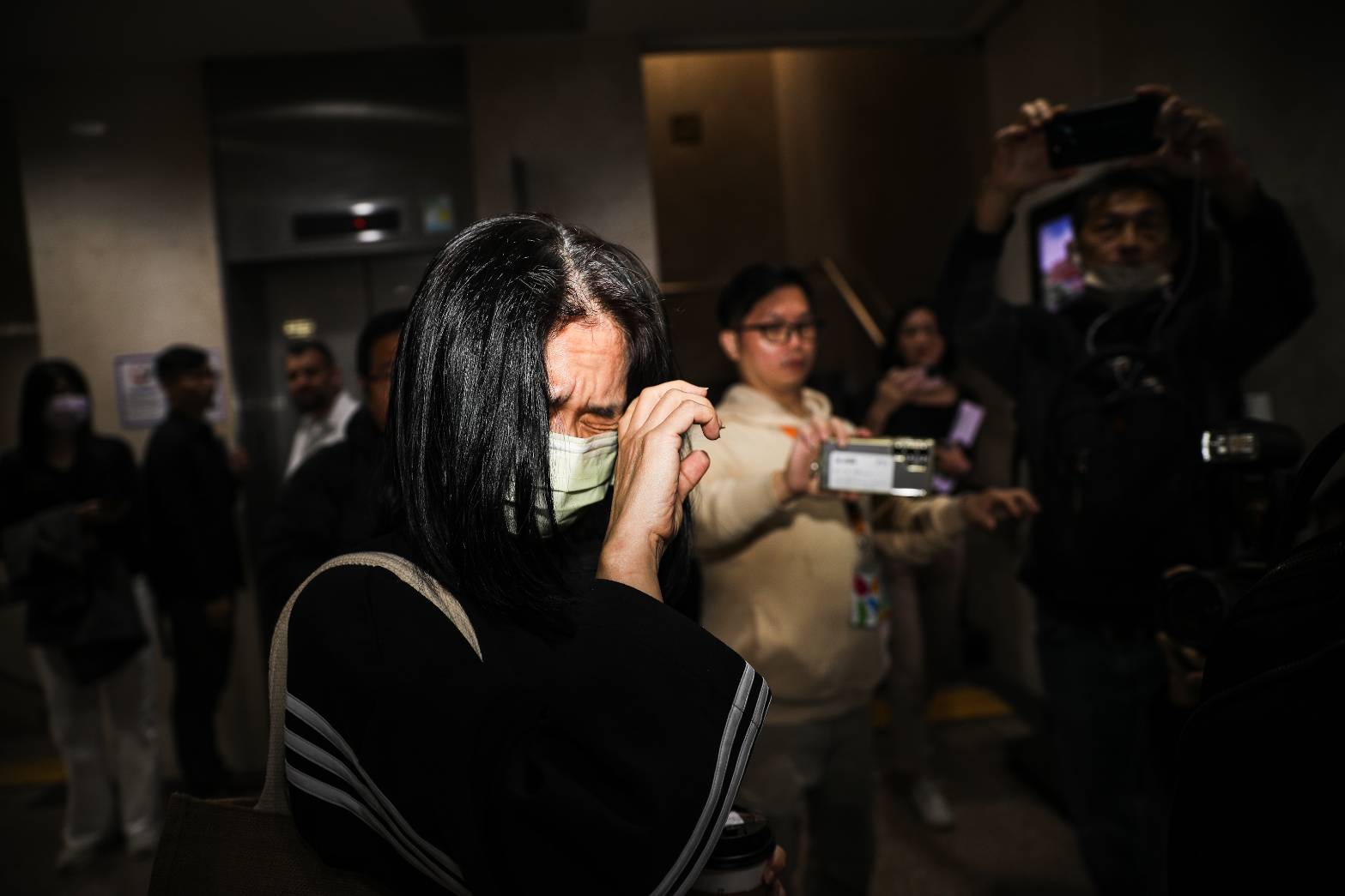 李文娟遭傳喚到案,面對鏡頭皺眉閉眼。