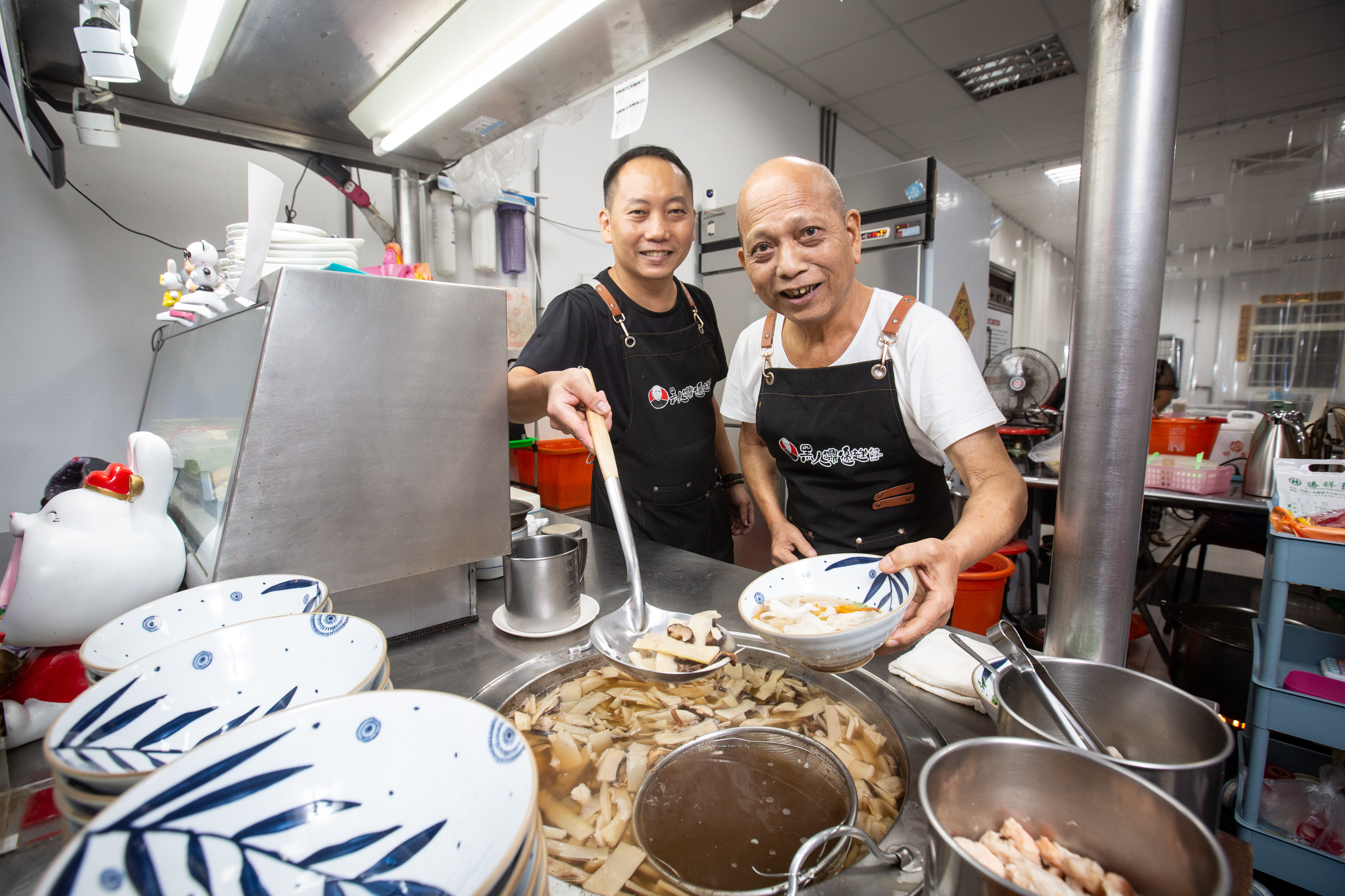 老總鋪師唐賢次（右）50多年前在桃園街邊開始賣鼎邊趖，小兒子唐茂檳（左）7年前見父親年邁，辭去穩定工作，從頭學起接下老店。
