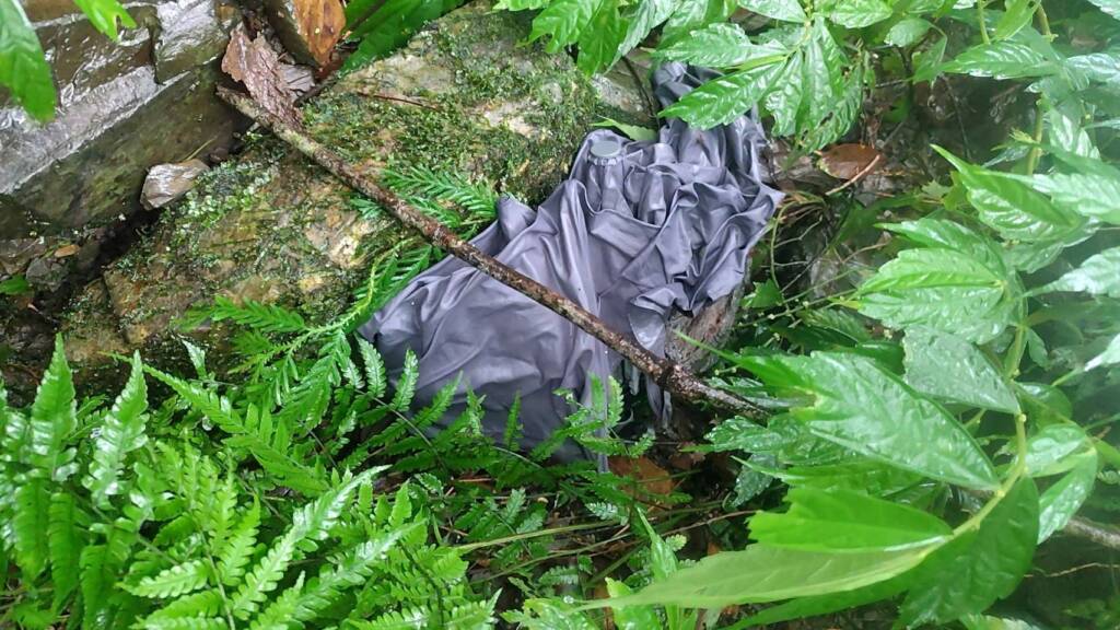 一名鍾姓男子攀登宜蘭古魯林道失聯，警消在搜救過程中尋獲鍾男遺落的雨傘。（翻攝畫面）