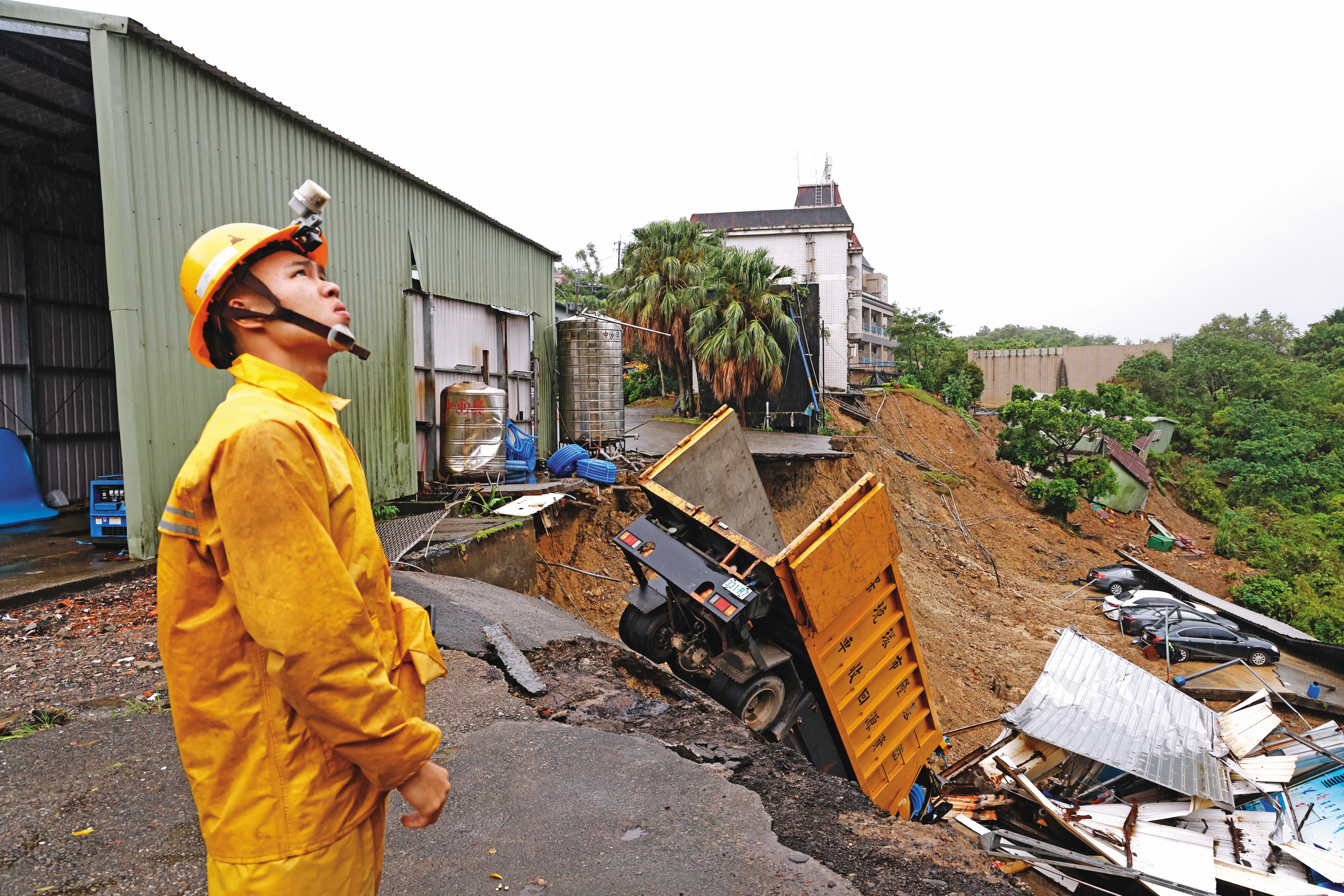放不放颱風假，颱風還沒來先放假，颱風過後還放假都是政治學。圖為山陀兒颱風造成基隆天外天垃圾場旁山壁坍塌，10多輛車遭土石掩埋。（杭大鵬攝）