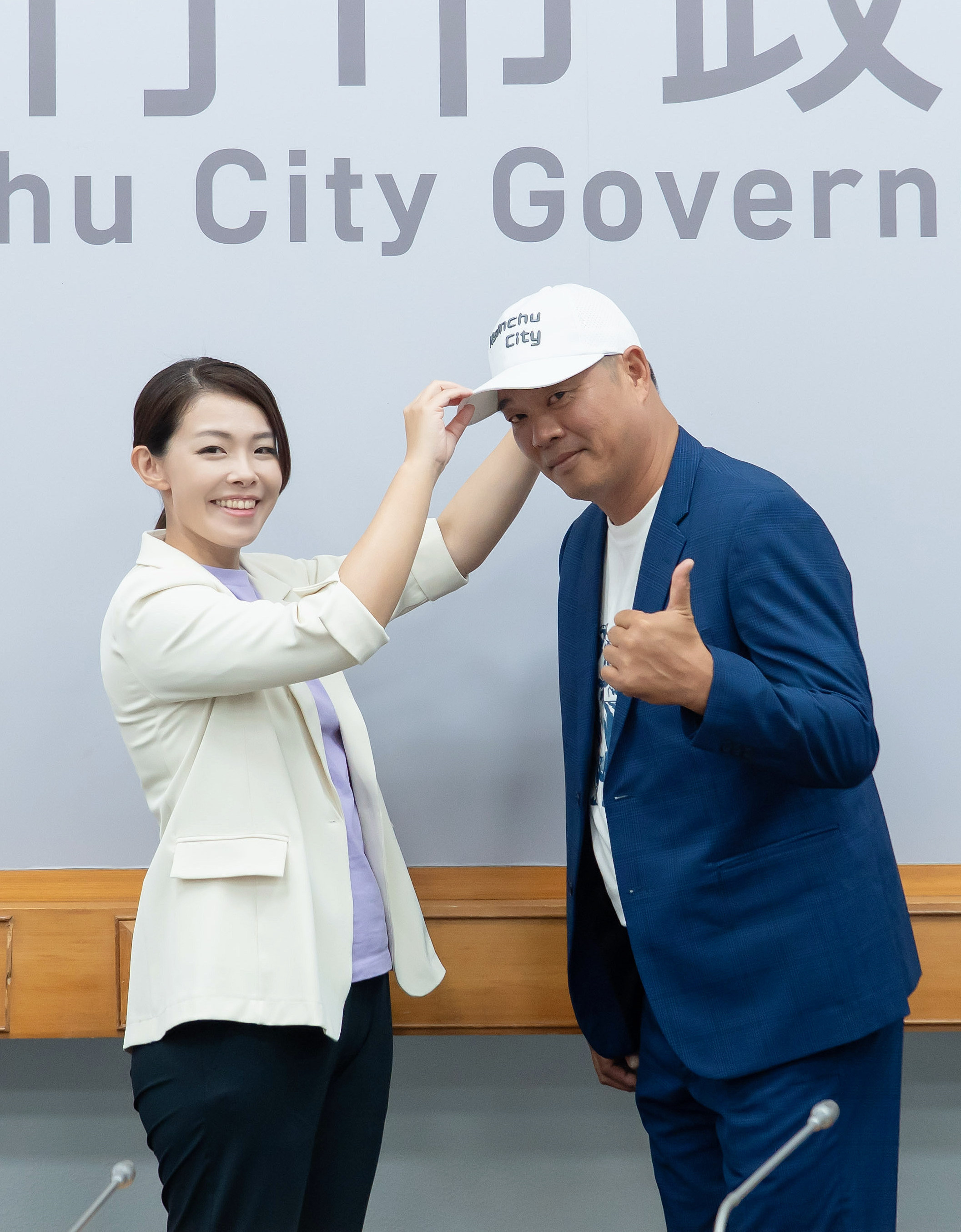 高虹安（左）為陳瑞振（右）授帽，象徵新竹市城市棒球隊正式啟航。（新竹市政府提供）