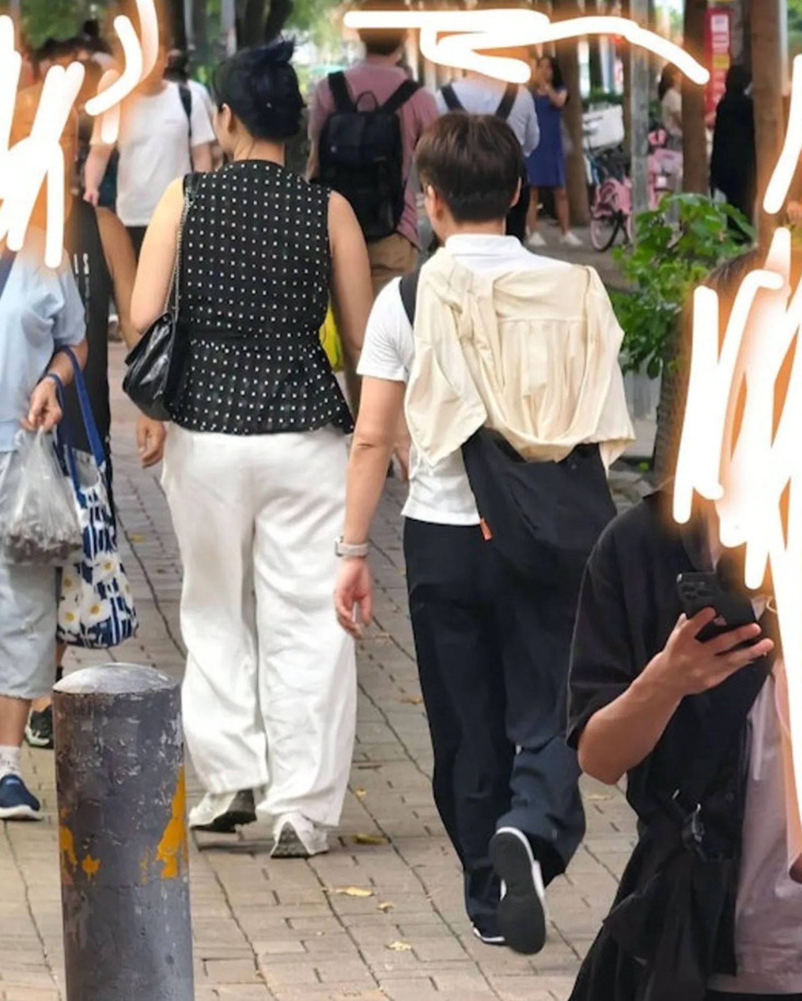 苦主公布黑衣女與白衣同夥的背影照片，提醒網友留意壁咚詐財的手法。（翻攝將軍澳主場臉書）