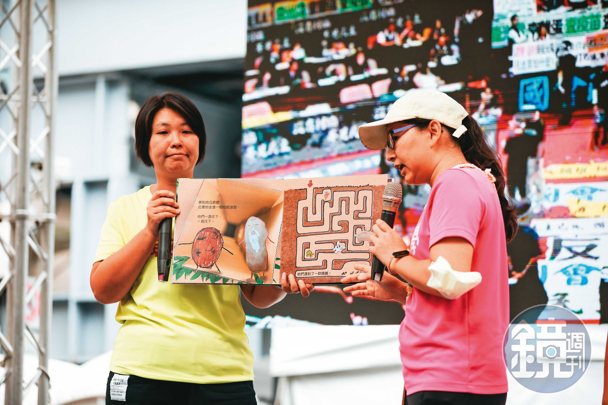 台灣親子共學教育促進會在舞台上朗讀繪本，手上拿的是親子共同以「竹科三期開發案」為本創作、談程序正義議題的《地瓜打嗝了》。