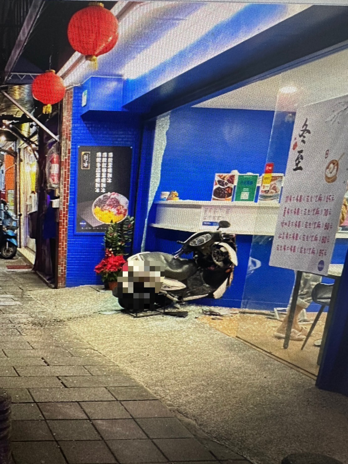 阮女機車突然暴衝撞進飲料店,車頭還卡在櫃檯裡。(翻攝畫面)