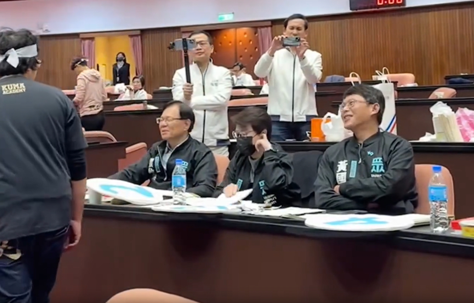 《選罷法》第76條今中午表決通過，昔日反對的黃國昌也舉手同意，面對綠委沈伯洋批評，黃國昌笑笑不予回應。（翻攝自民進黨團Threads）