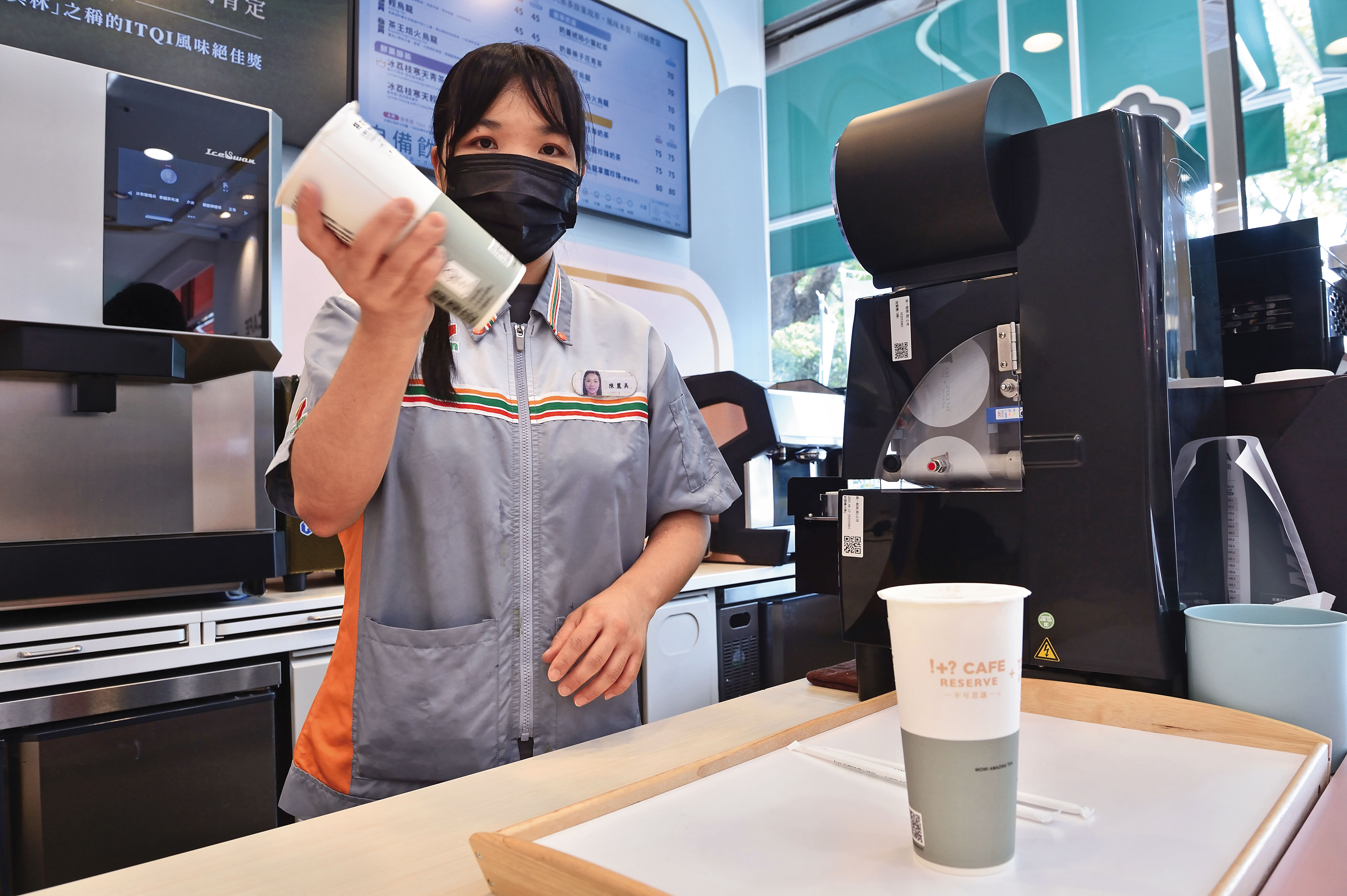 統一手搖茶飲店的工作人員，身穿經典的小七配色制服。