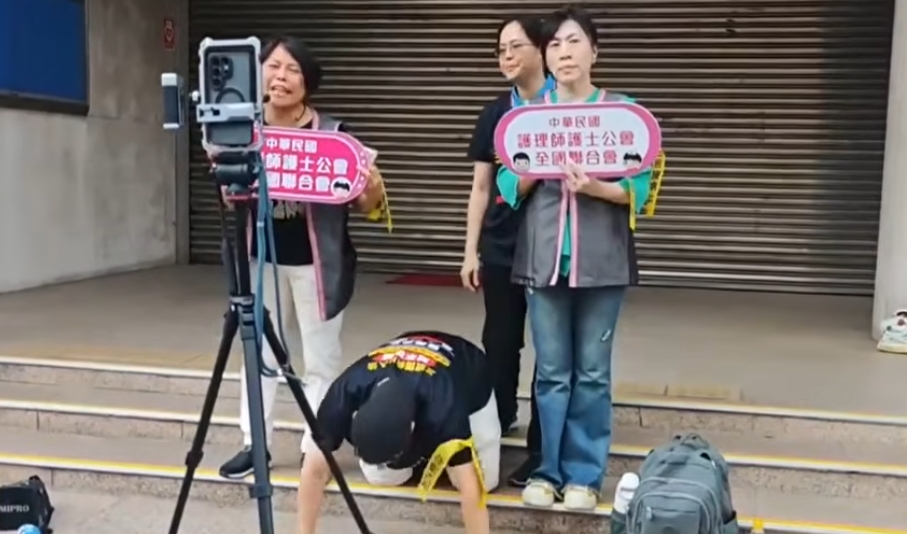 護理團體來到立法院外抗議,甚至下跪磕頭盼立委不要退讓護理人員比例。(鏡新聞)