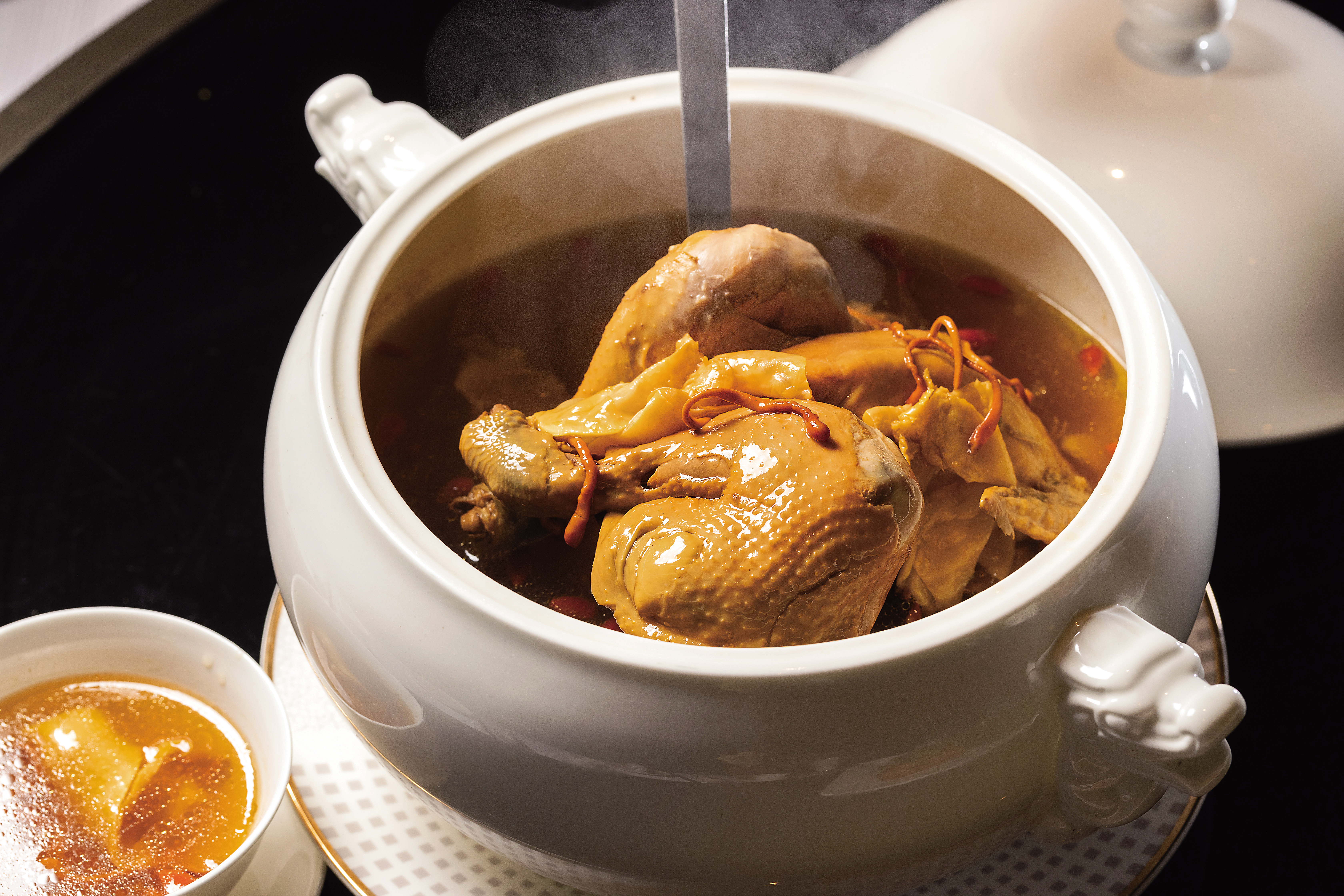 香宮的「黃金蟲草花乾螺燉30頭清水花膠雞湯」，以蟲草花、乾螺頭、花膠熬製，是春日滋補湯品。（33,888元宴席菜色，單點1,688元／1人份）