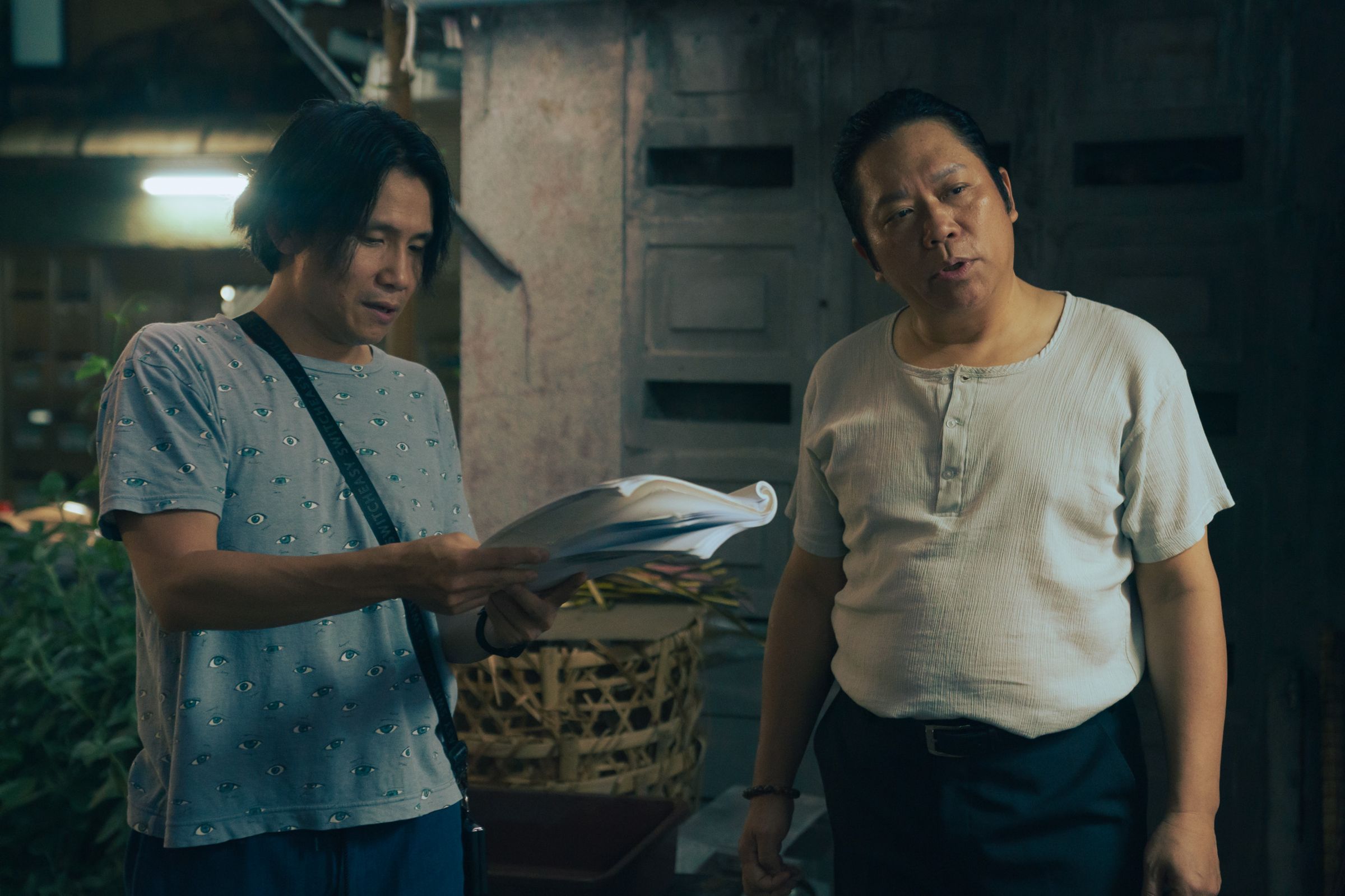 編導游紹翔（左）與飾演甘蔗汁店老闆的卜學亮（右）在現場討論劇情。（壹壹喜喜提供）