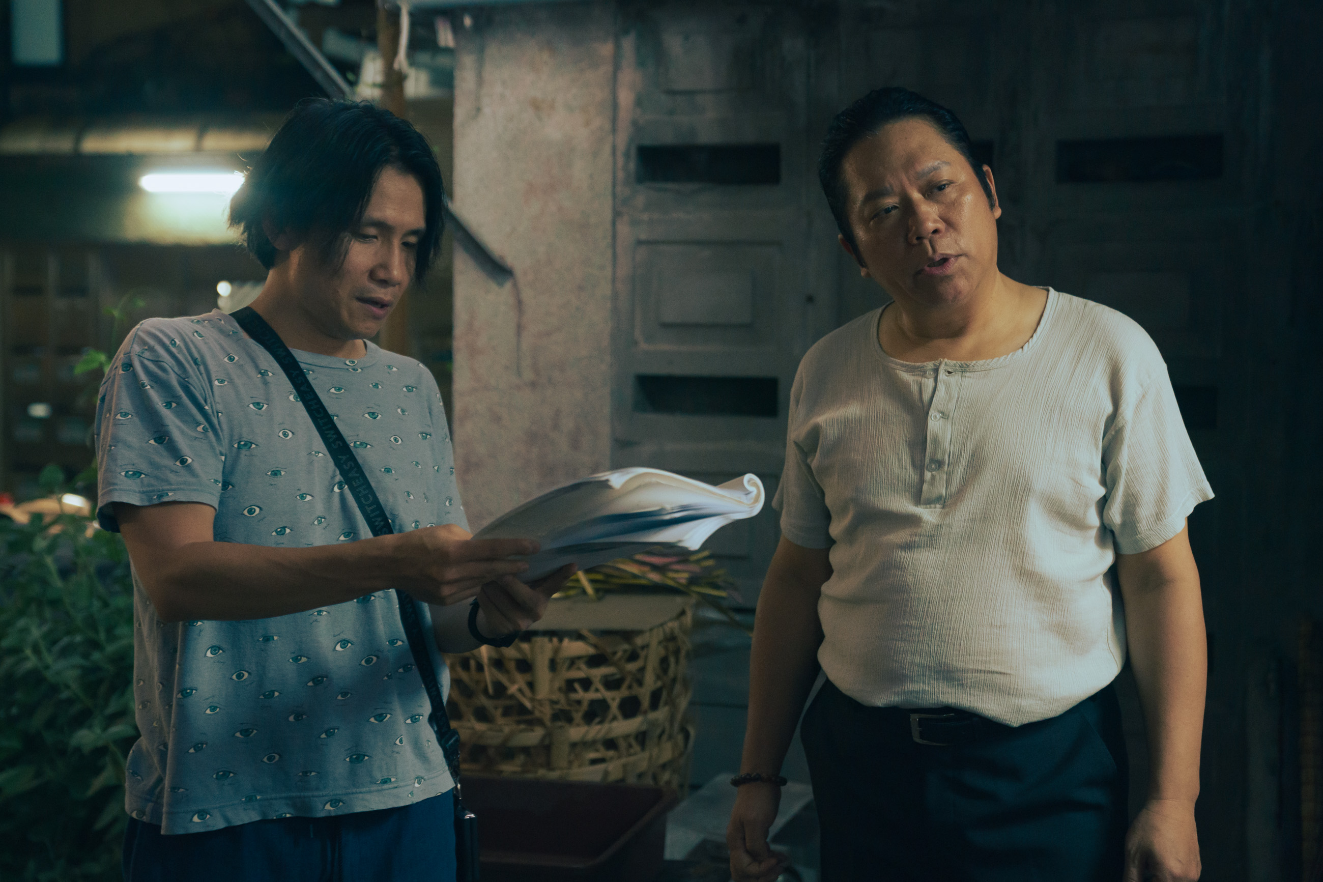 編導游紹翔（左）與飾演甘蔗汁店老闆的卜學亮（右）在現場討論劇情。（壹壹喜喜提供）