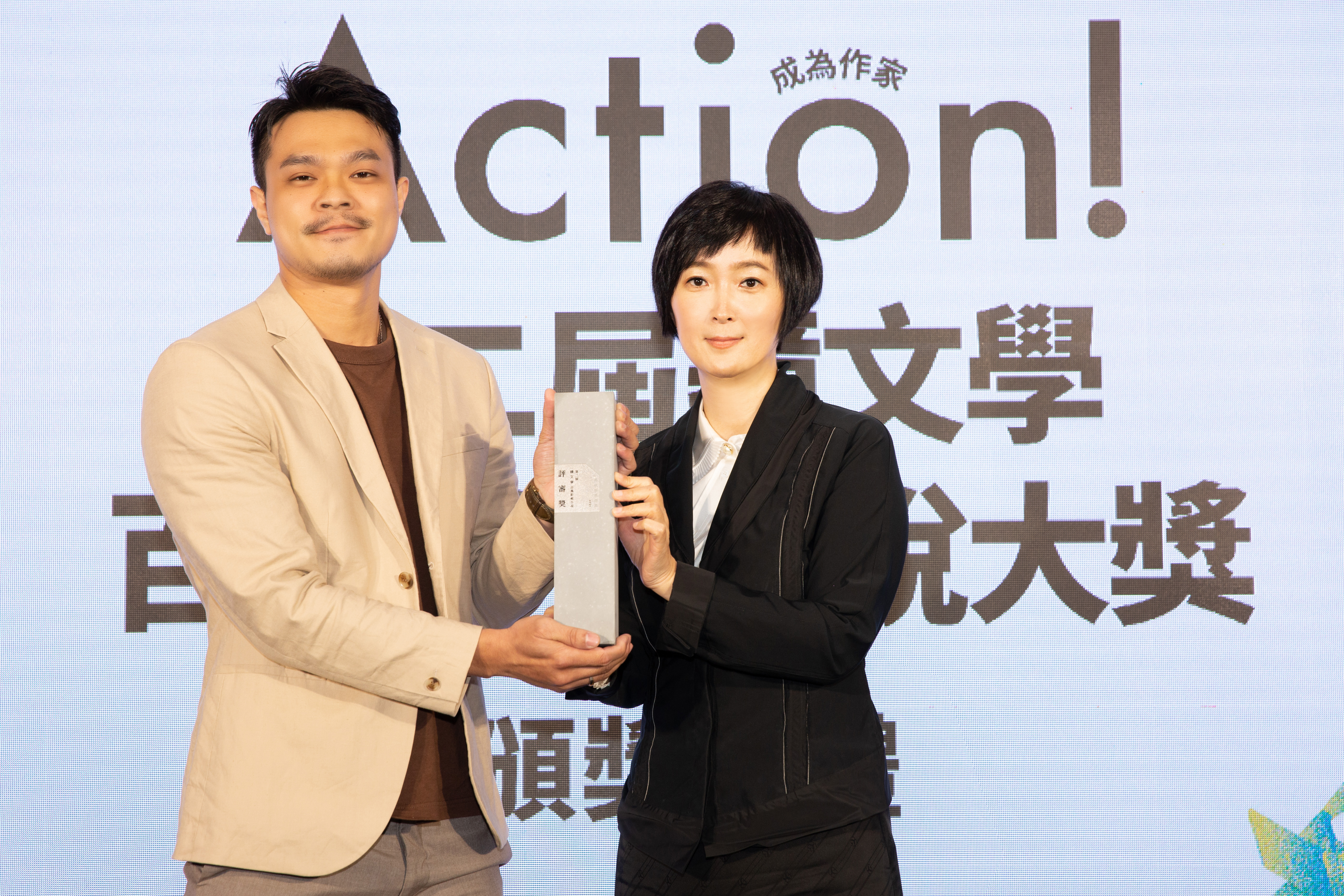吳威邑(左)以《最後的魔術家族》獲第二屆鏡文學百萬影視小說大獎評審獎,由鏡文學總經理兼總編輯董成瑜(右)頒獎。(鏡文學提供)