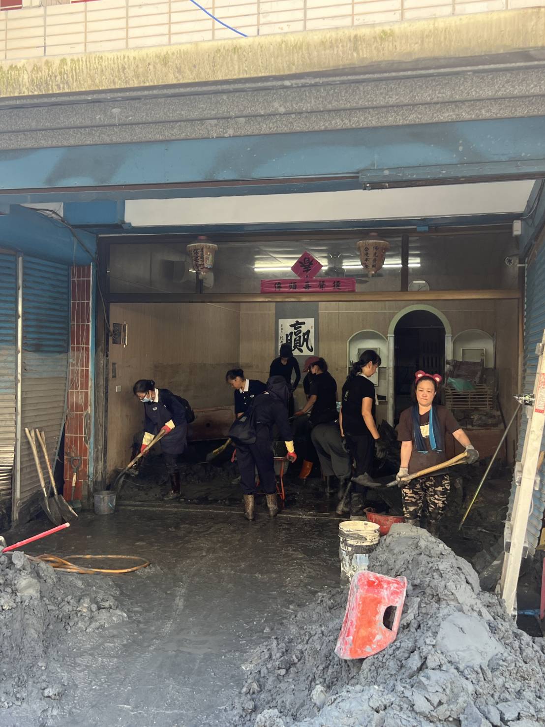 幫忙清理的志工跟居民家的贏字畫。