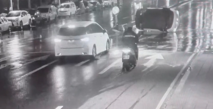 一名特斯拉駕駛酒駕自撞分隔島，當場車子側翻、左前輪胎瞬間噴飛。（翻攝畫面）