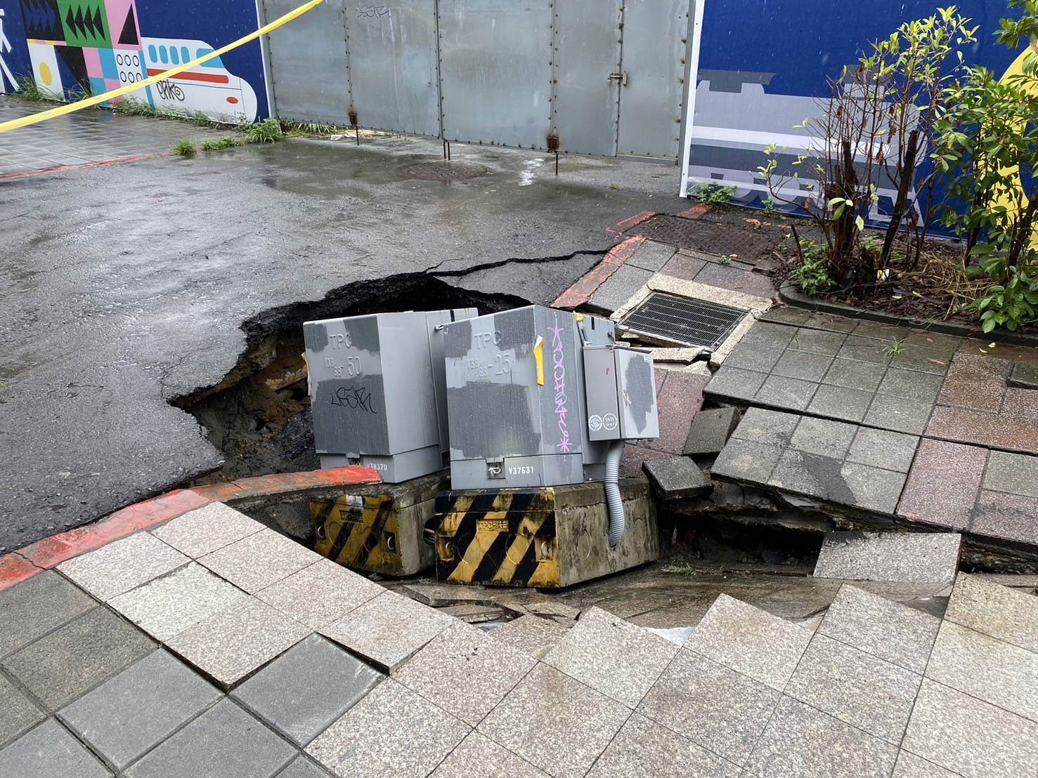台北市捷運北門站外人行道突然下陷，變電箱好似被吞入。（翻攝畫面）