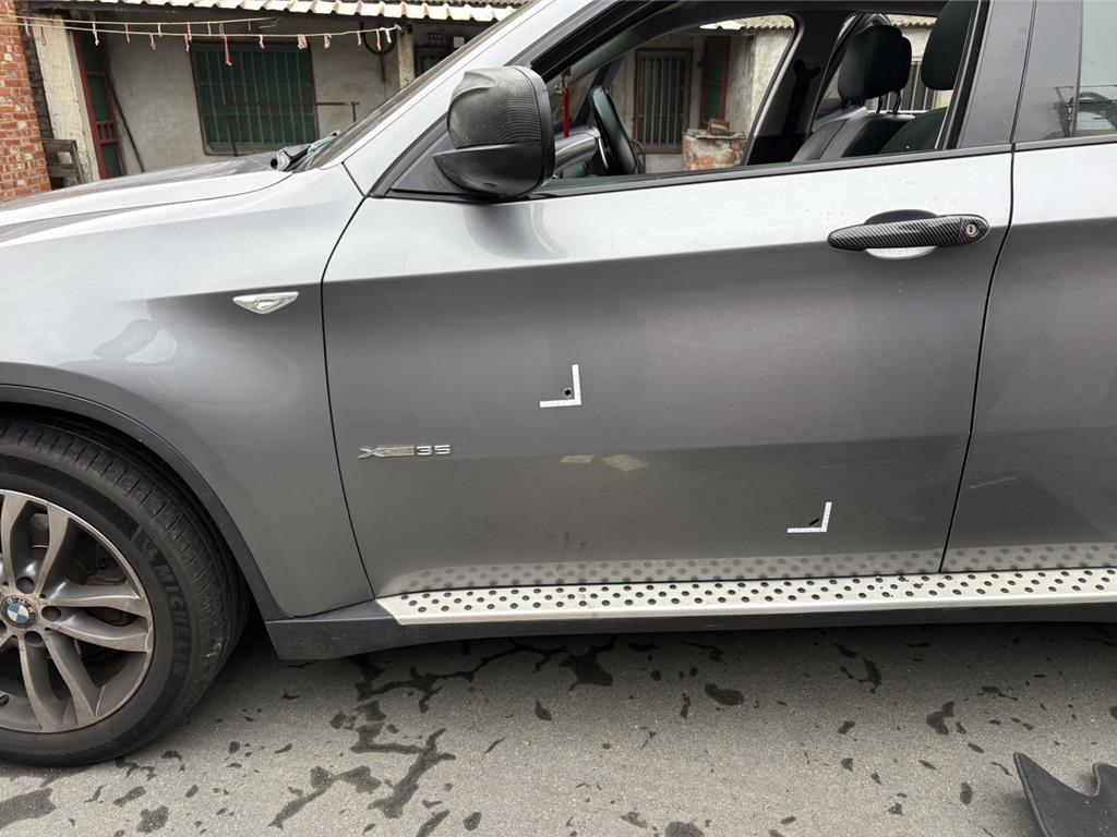 吳男駕駛的駕車遭警方朝輪胎開槍,其中一槍子彈貫穿車門。(翻攝畫面)