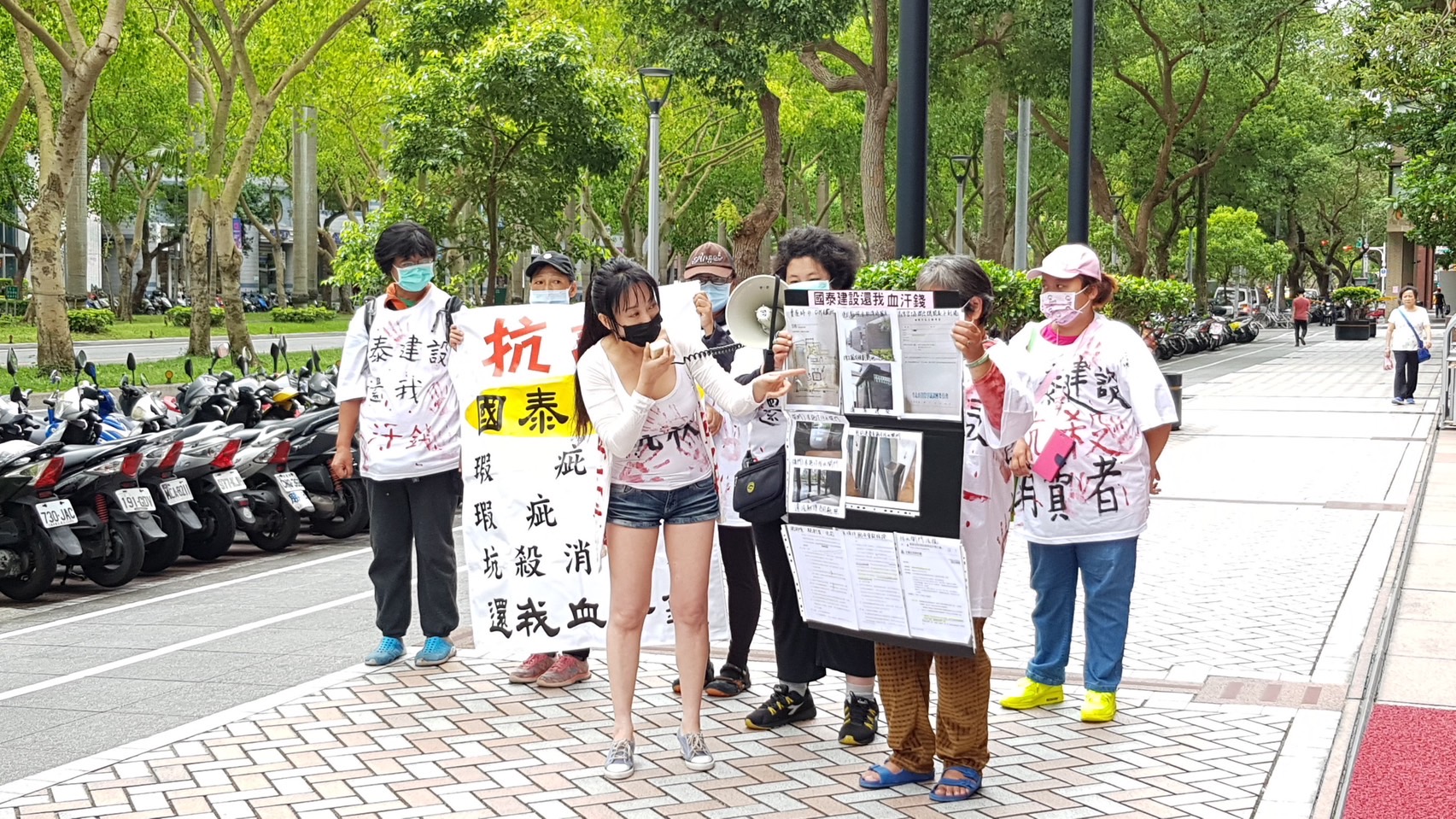 豪宅屋主葉女不滿國泰建設房屋缺失，到國泰人壽大樓前舉白布條怒槓建商。（讀者提供）