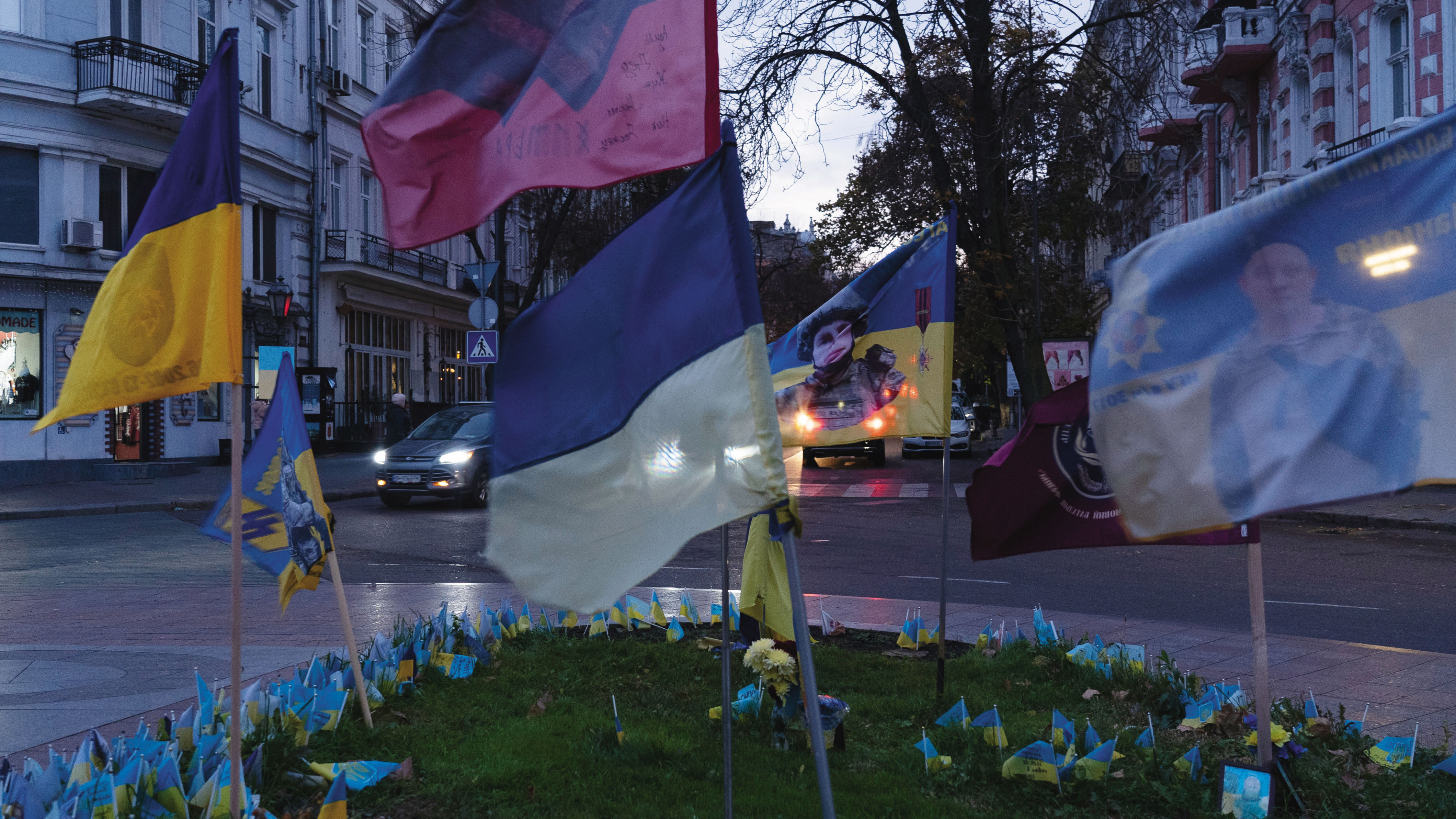 路口圓環成了令人揪心的紀念所，烏克蘭國旗和殉難士兵肖像並列，向他們的英勇犧牲致敬。