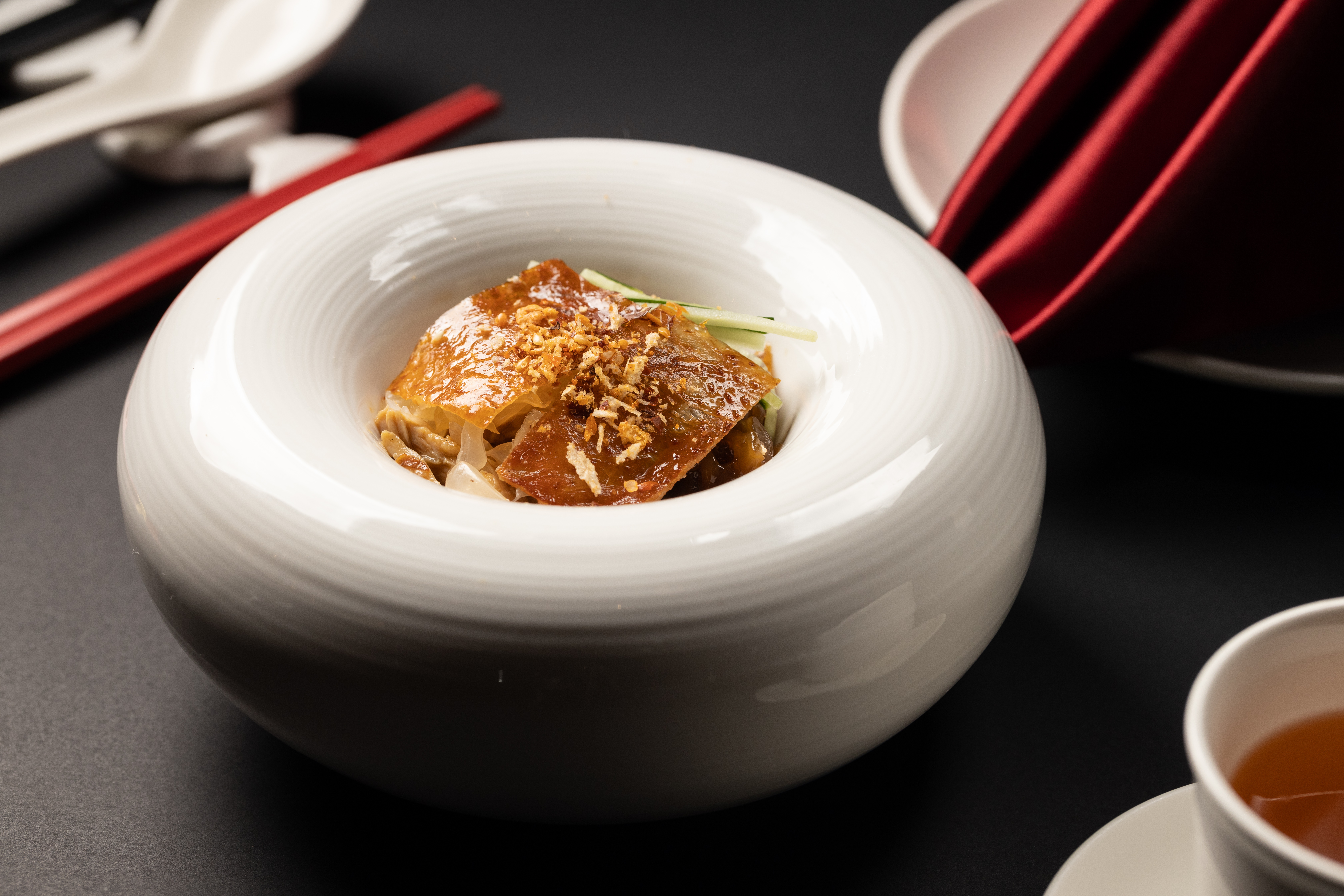 「川味脆皮手撕雞拌蜇頭」是川粵風味的巧妙結合。（粵宴套餐菜色，3,800元／人）