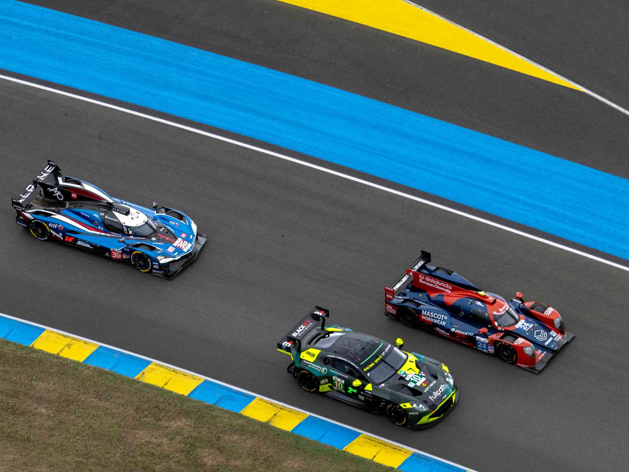 利曼 24 小時耐力賽採「混組合賽」，三個不同組別的車款同場競技。圖中左車為 ALPINE A424 Hypercar，中為 ASTON MARTIN Vantage AMR LMGT3 車款、右為 LMP2 車款。