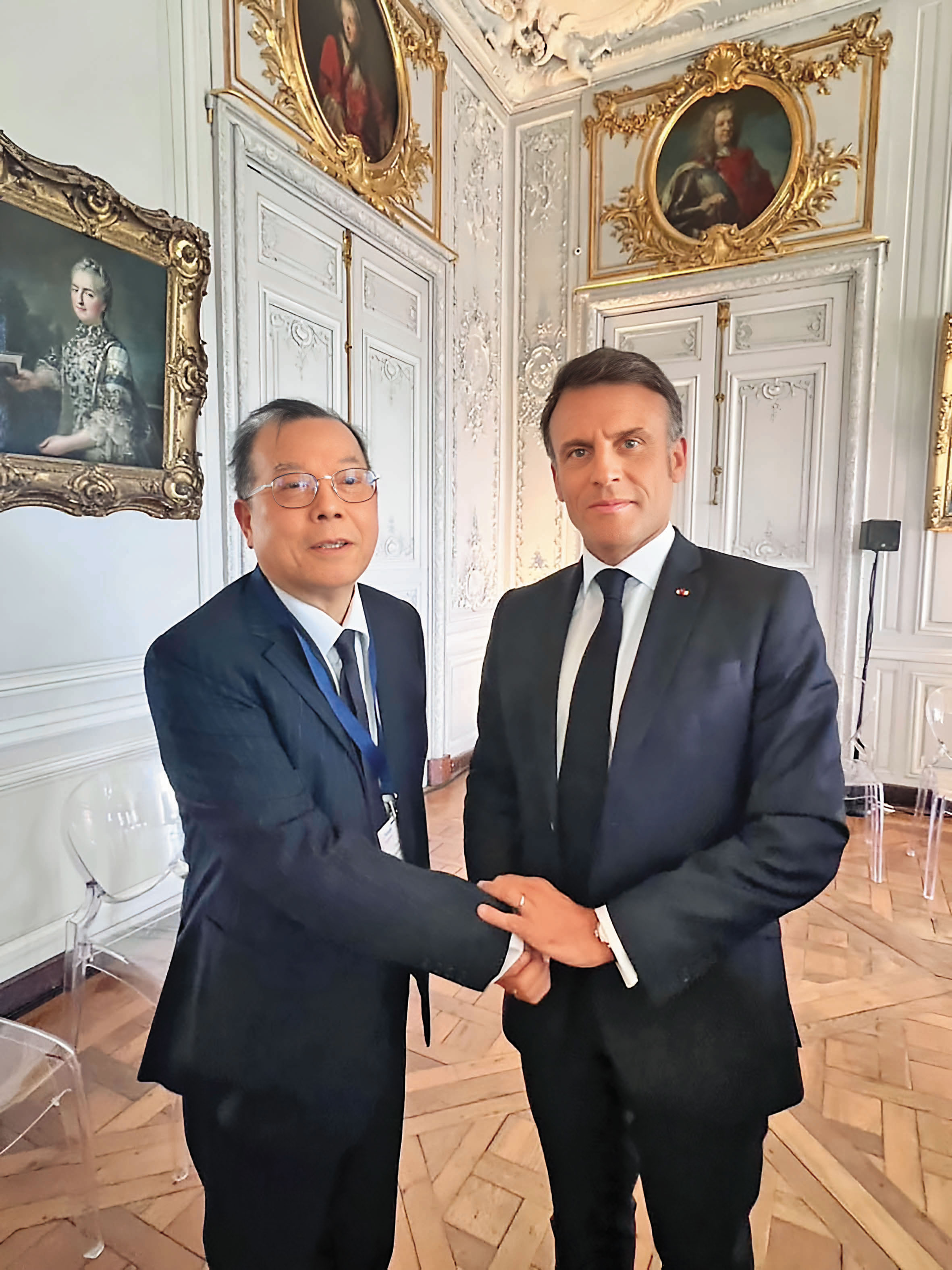 黃崇仁（左）與法國總統馬克宏（右）見面時，化身外交大使推銷台灣。（力積電提供）