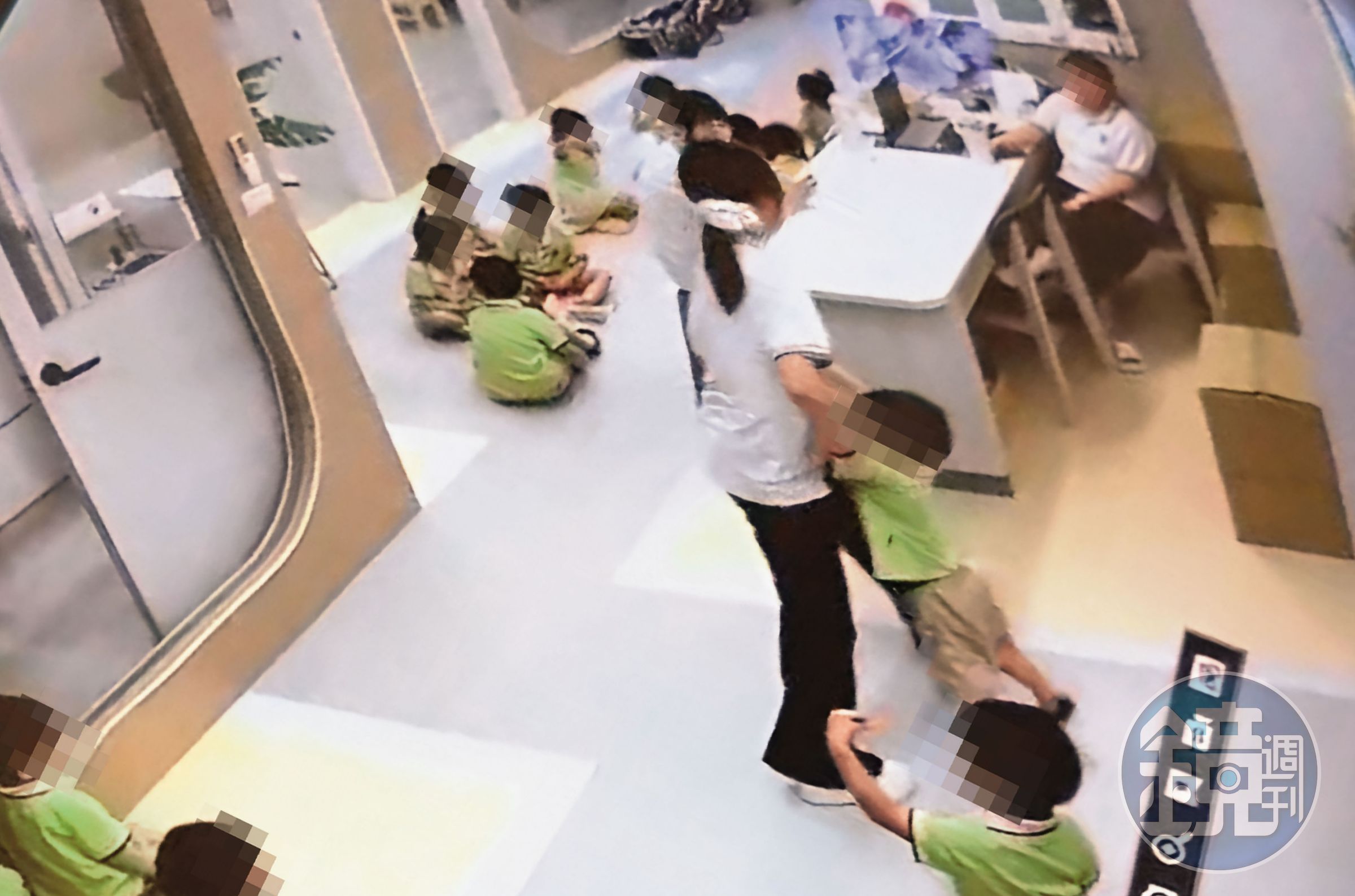 趙姓老師將幼童抓起,猛力拖行至桌椅區。(讀者提供,被害人已變裝處理)