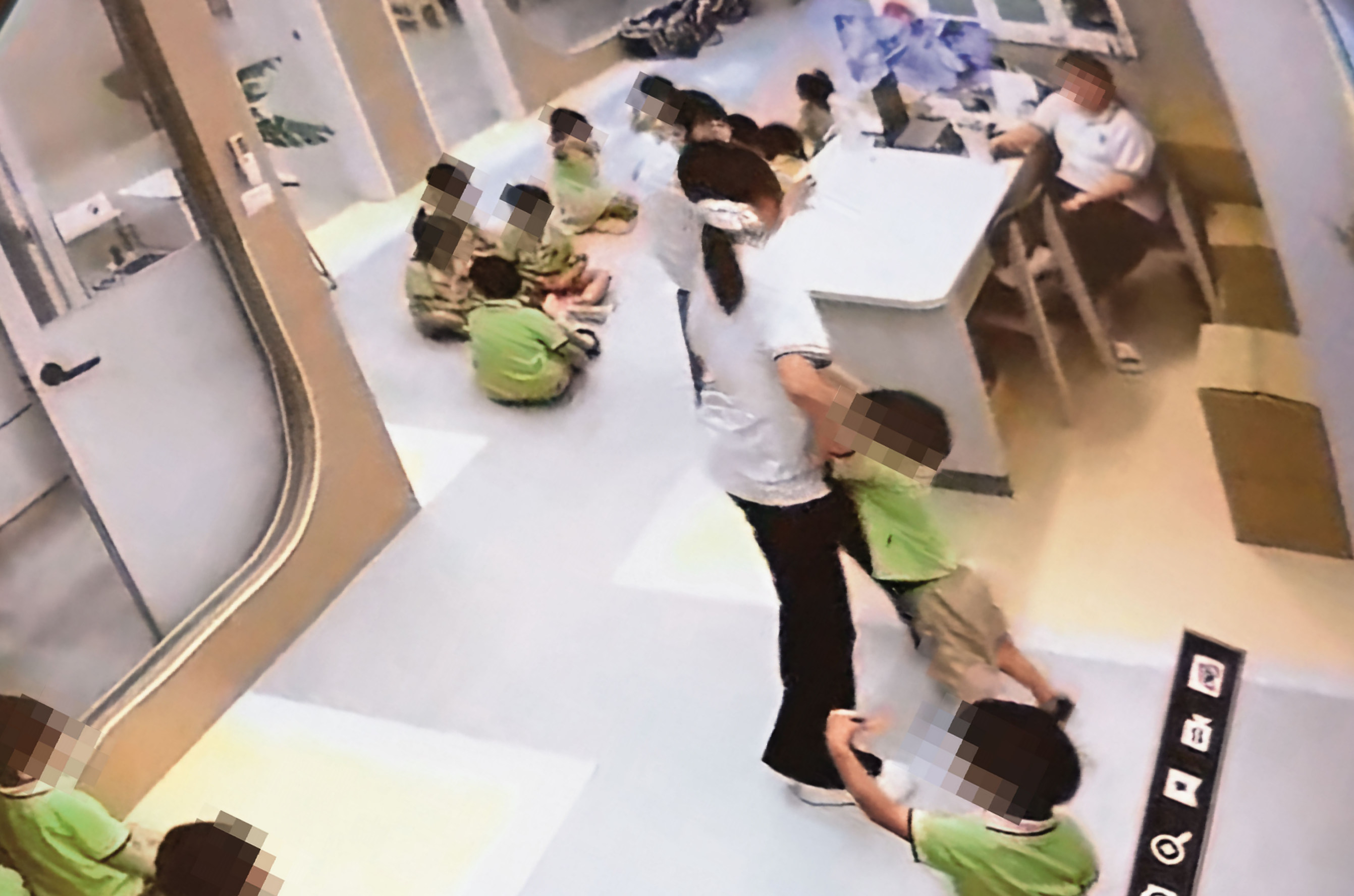 趙姓老師將幼童抓起,猛力拖行至桌椅區。(讀者提供,被害人已變裝處理)