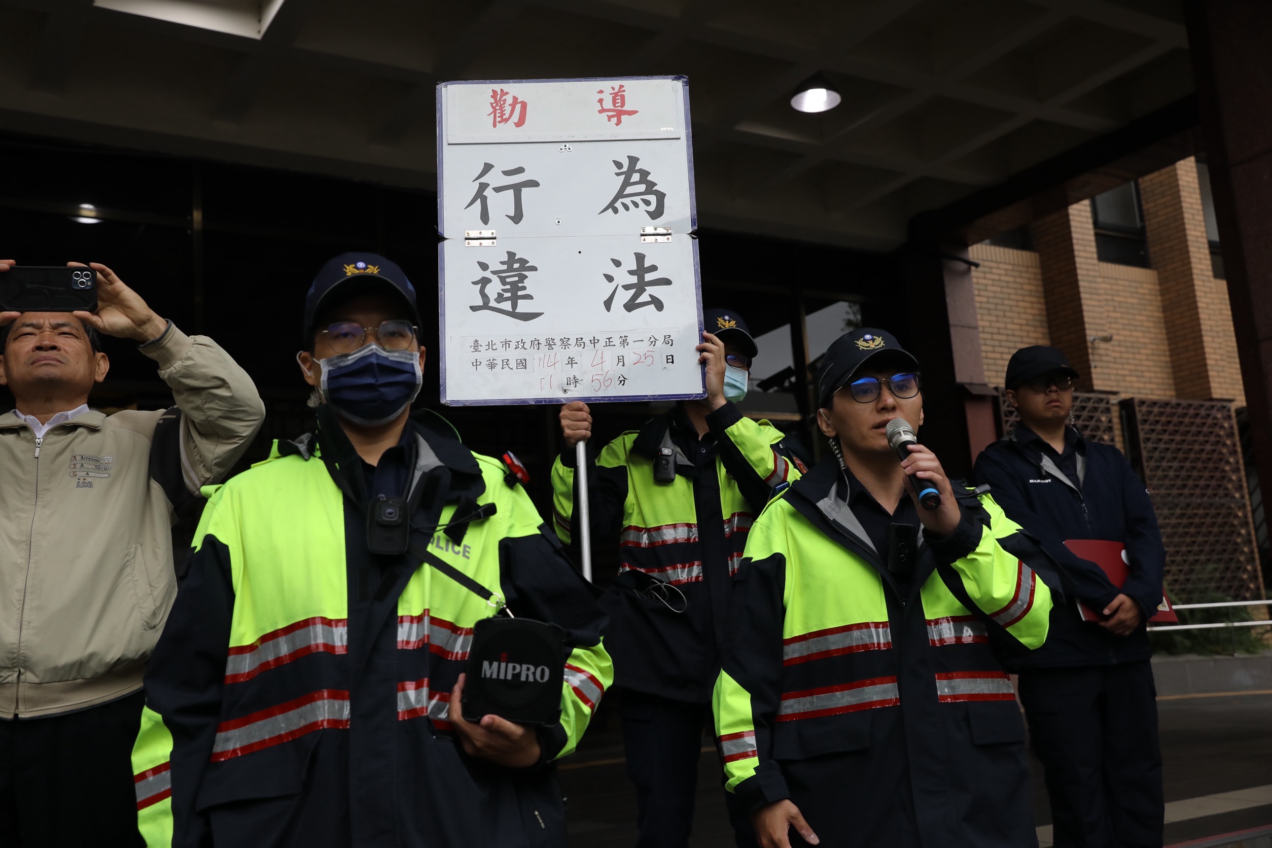 台北市警方針對在管制區內聲援黃呂錦茹群眾舉牌警告。