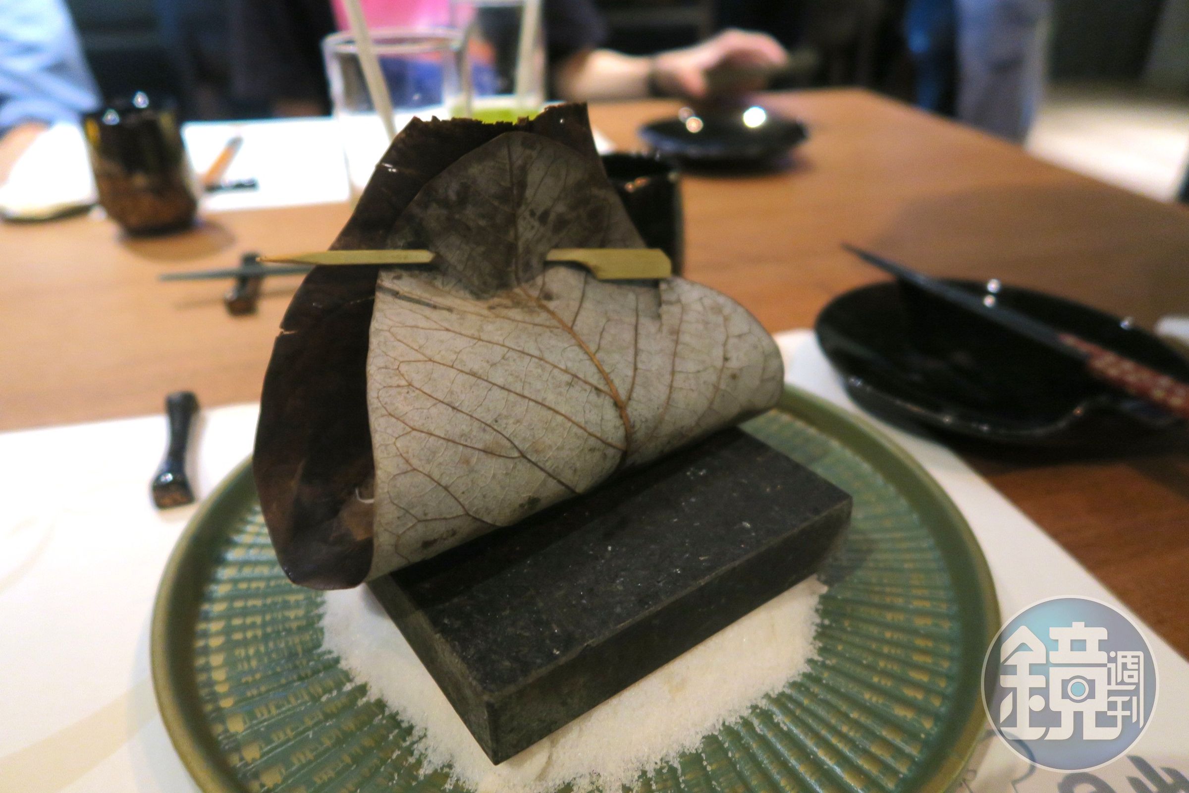 粗鹽上墊著燒熱的石板,板子上擱著固定好的朴葉和牛,視覺效果很棒。