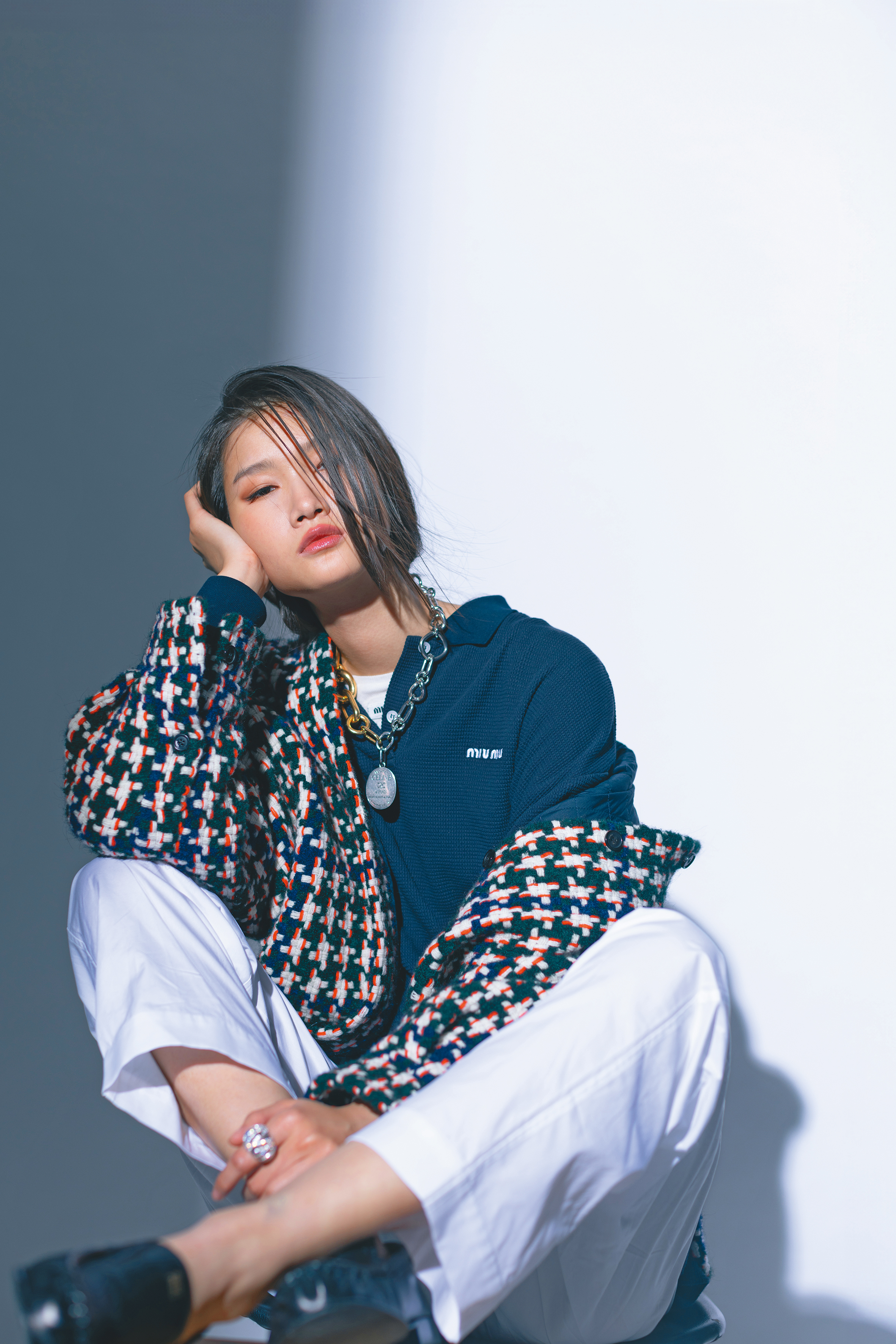 羊毛混紡夾克襯衫 NT$111,000 by LOEWE；深藍色polo衫 價格店洽 by MIU MIU；白色針織上衣 價格店洽 by MIU MIU；白色長褲 價格店洽 by MIU MIU；樂福鞋 NT$38,000 by MIU MIU；CELINE CHARMS MODERN銀色飾面飾鍊 NT$26,000 by CELINE；CELINE CHARMS MODERN金色飾面粗飾鍊 NT$48,500 by CELINE；MAISON CELINE銀色飾面徽章吊飾 NT$11,500 by CELINE；個性Enlacé戒指 NT$7,100 by APM MONACO。 