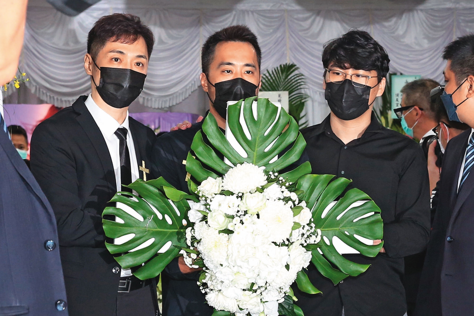 陳鑒（右一）在妻子的喪禮上承諾會好好照顧小孩，如今卻淪為詐團車手頭。