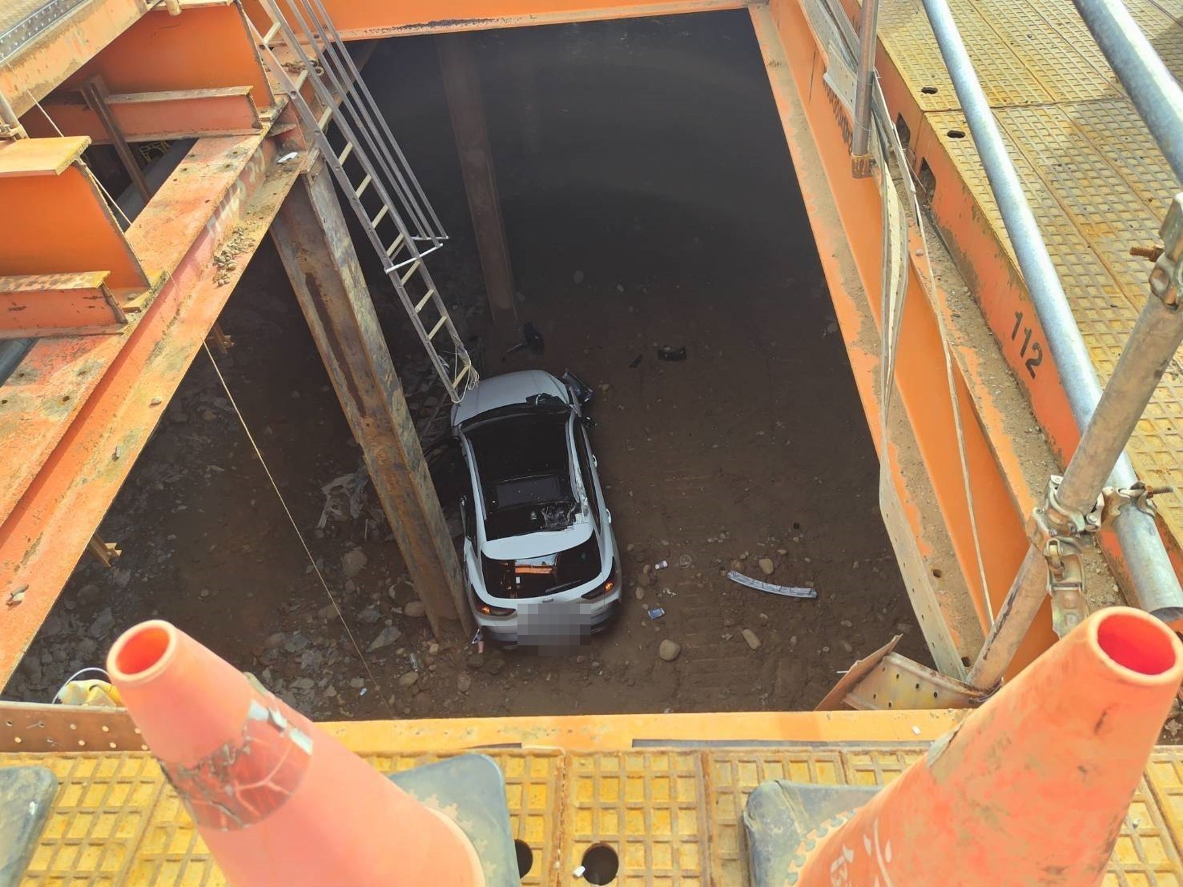 桃園女駕駛今日下午疑似恍神,竟駕車直闖捷運工地,掉進正在開挖的地下室。(翻攝畫面)