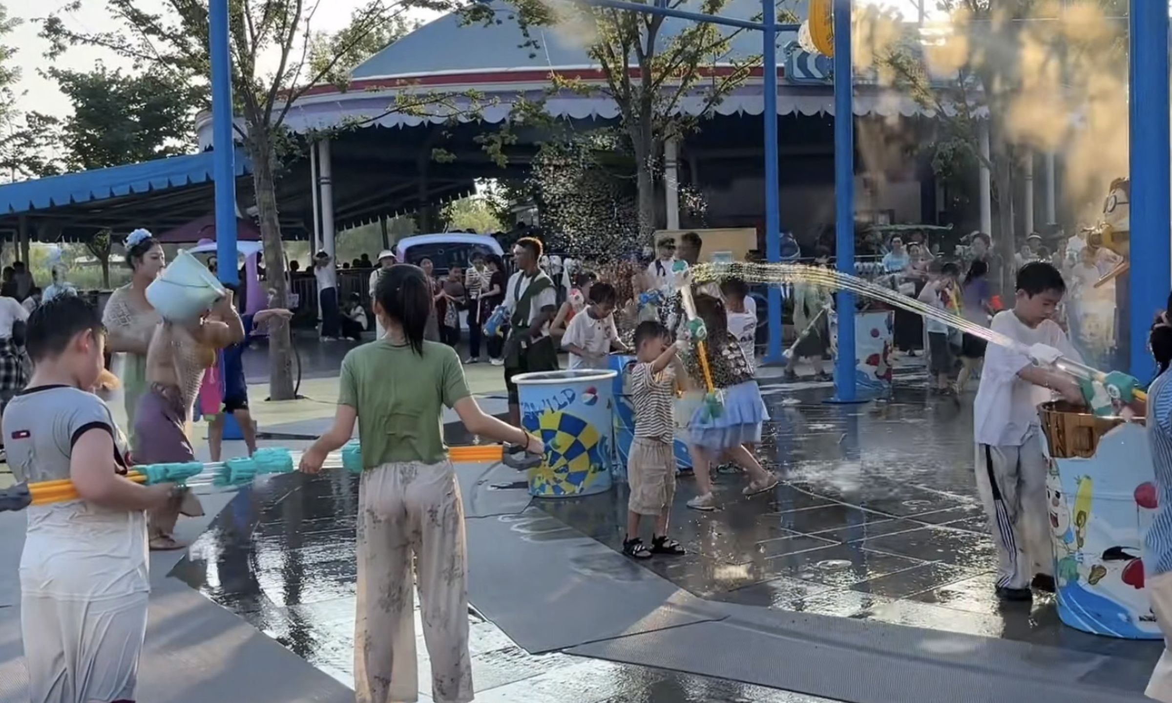 一名女童在水上樂園的「打水仗區」遭到一名NPC故意用水桶砸擊。(翻攝自微博)