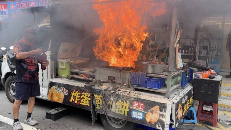基隆一輛停在路旁的炸蛋蔥油餅餐車，昨日下午老闆作業時突然油鍋起火，火勢相當猛烈，嚇壞老闆和路人。（翻攝畫面）