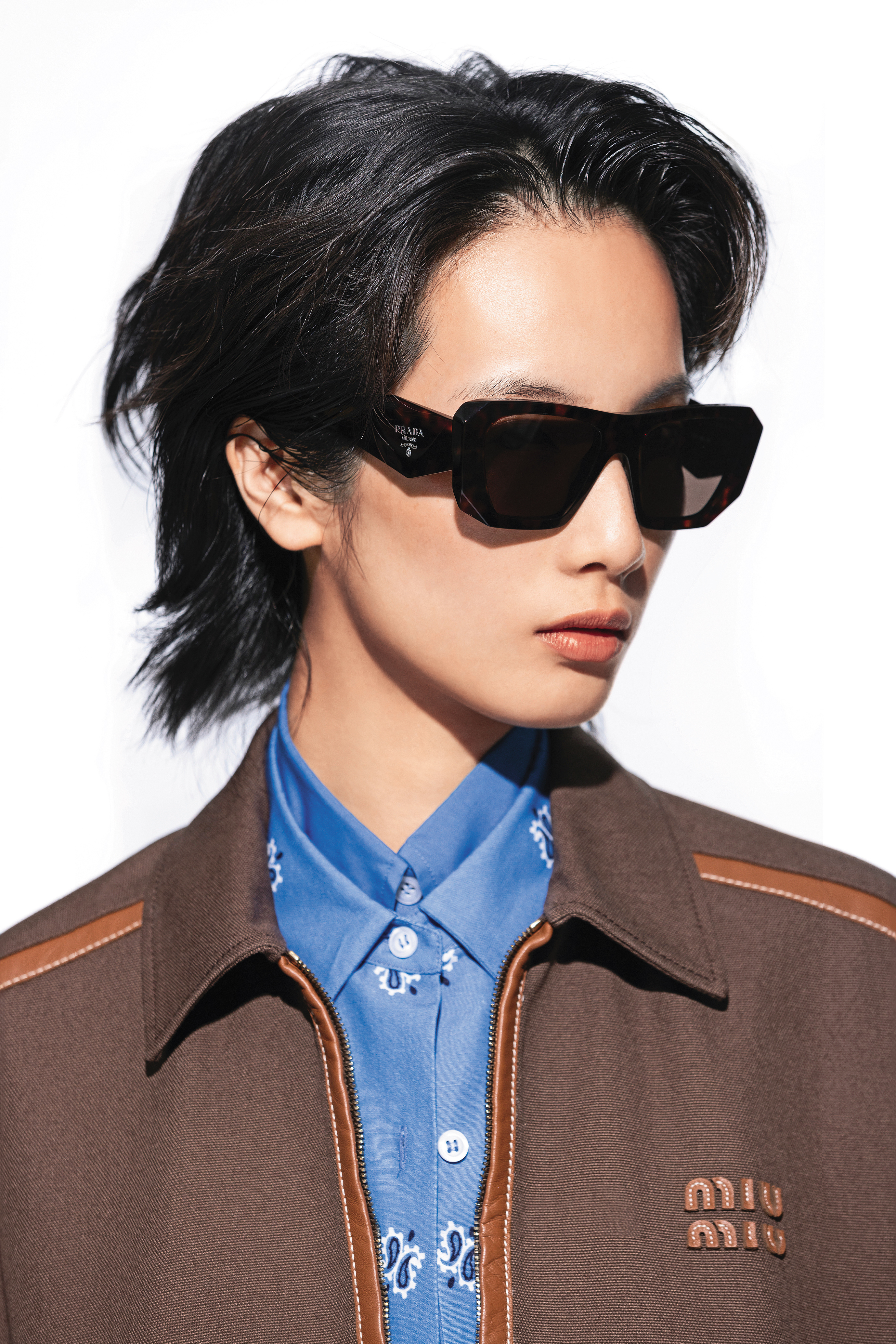 棕色棉質夾克 NT$140,000 by MIU MIU／棉質印花襯衫 NT$57,000 by MIU MIU／藍色棉質襯衫 NT$51,000 by MIU MIU。墨鏡 NT$16,000 by Prada。