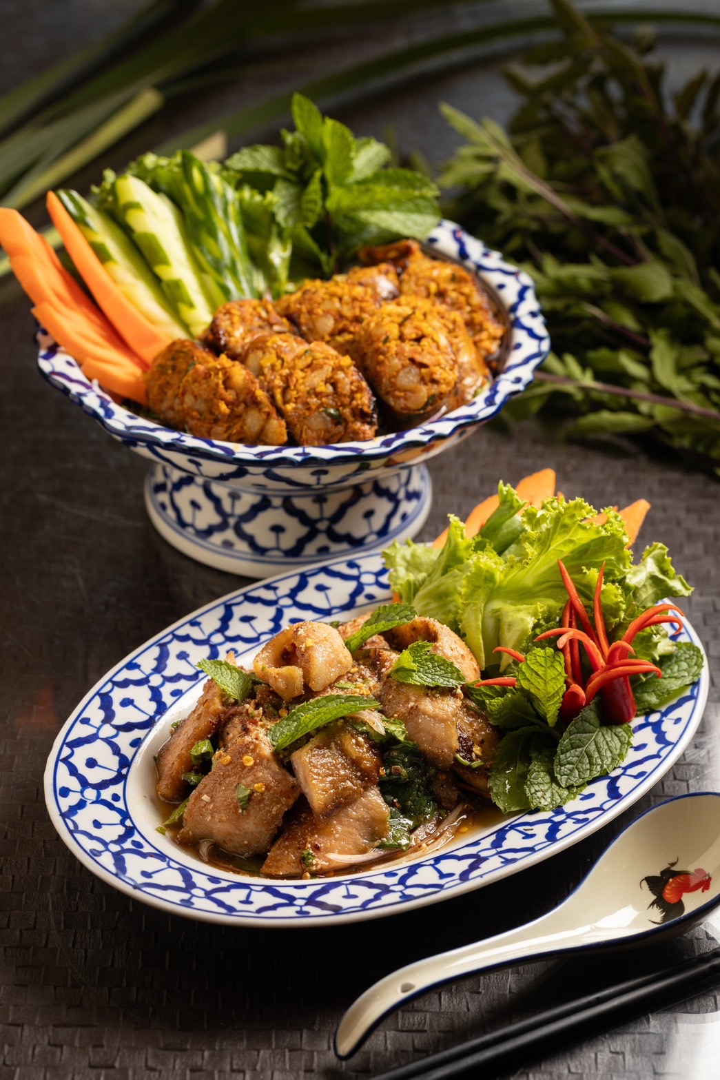 夏天吃起來涮嘴的「涼拌烤豬」（前，280元／份）Ｑ韌彈牙；香料風味滿滿的「泰北香腸」（後，290元／份）是隱藏版菜單。