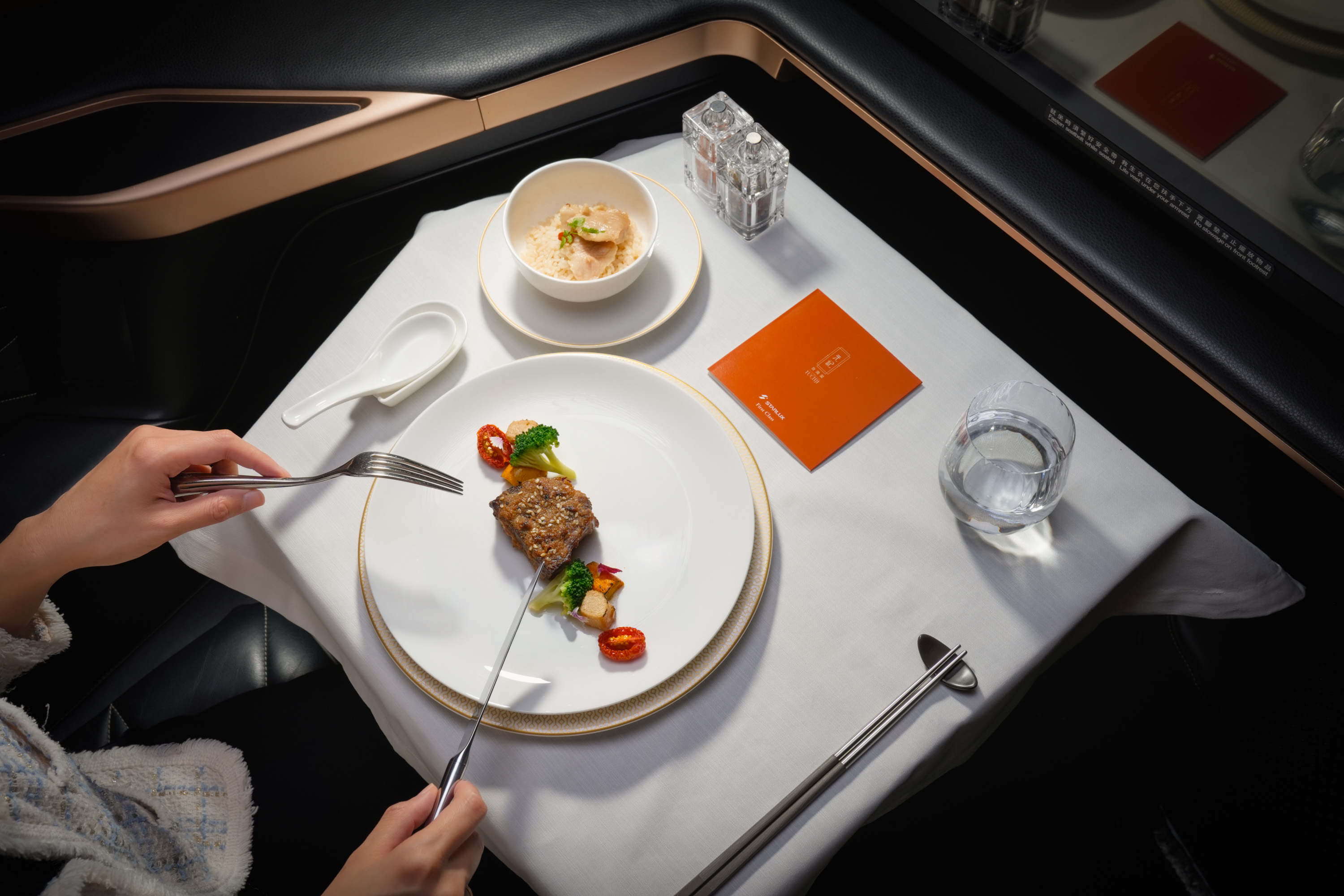 星宇航空持續攜手米其林一星「元紀．台灣菜」，10月1日起在台北出發長程航線換上秋冬新菜單，頭等艙、商務艙都能在高空吃到暖胃台灣味。（星宇航空提供）