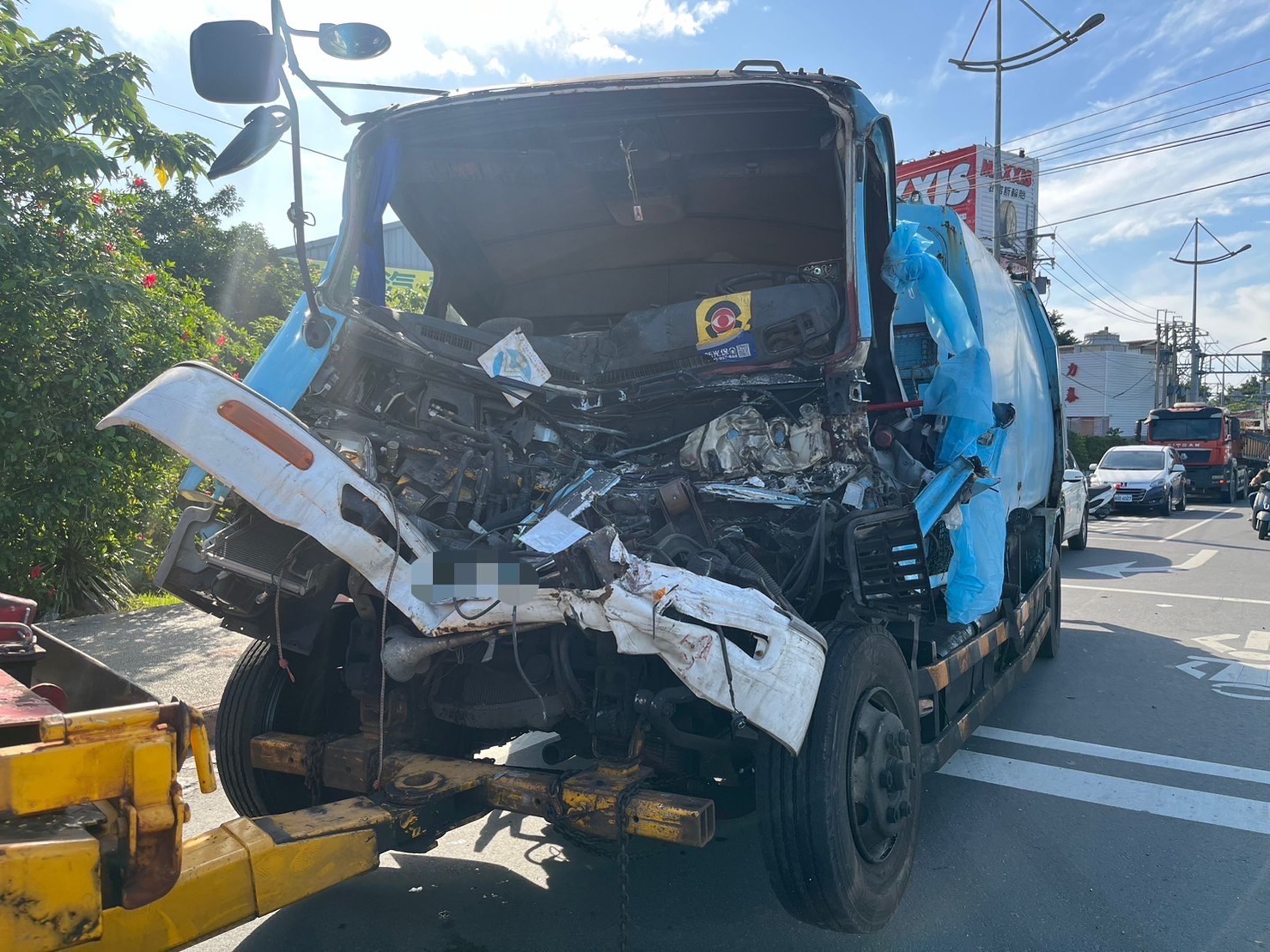 肇事垃圾車因撞擊力道猛烈,造成車頭全毀,駕駛一度受困。(翻攝畫面)