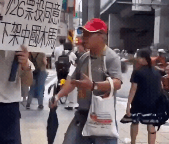罷免張智倫、林德福的志工團體在景安捷運站外宣傳，遭反罷免老翁持傘攻擊。（翻攝自倫刪立舒 - 中和罷免張智倫臉書）