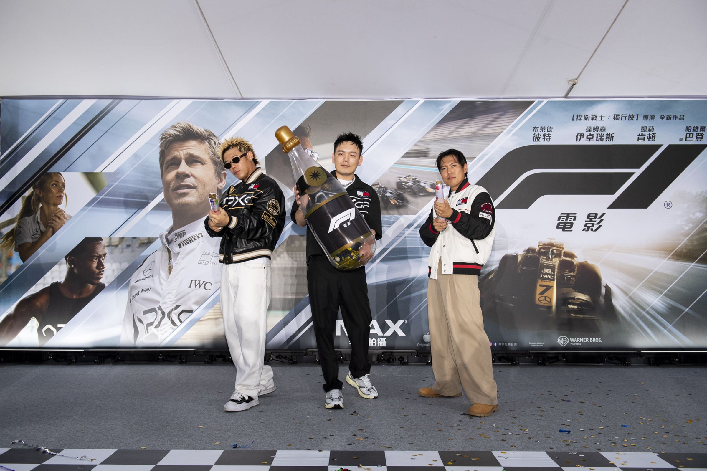 健志(左起)、春風、洋蔥身穿《F1電影》的聯名服裝,出席首映活動;健志與洋蔥的上衣,台灣僅有少量出售,目前已經缺貨中。(華納兄弟提供)