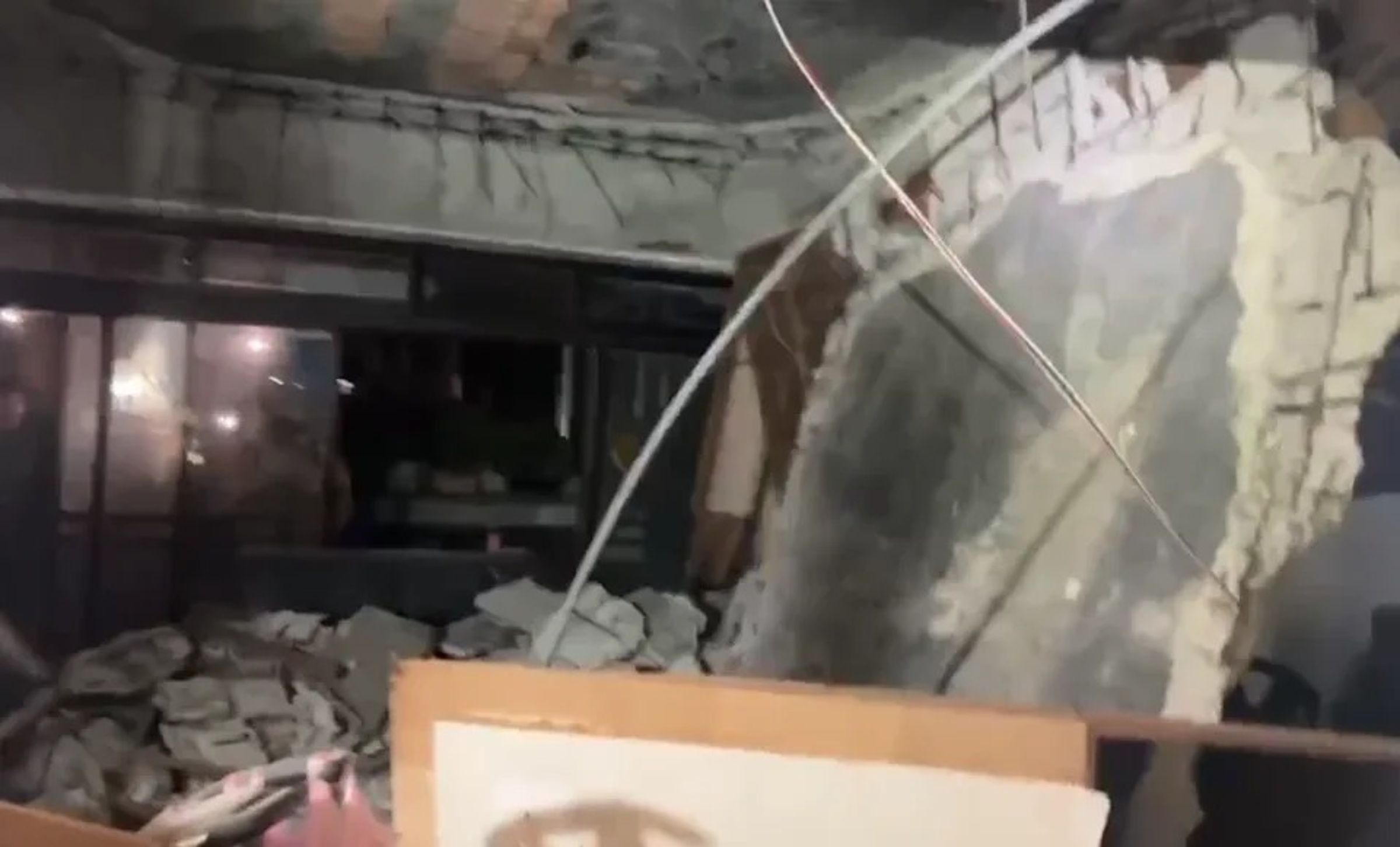 基隆市七堵區百福社區一棟公寓4層老舊公寓，3樓住戶的客廳水泥天花板突然整片掉落，碎石散落滿屋，場面相當驚險。（翻攝畫面）