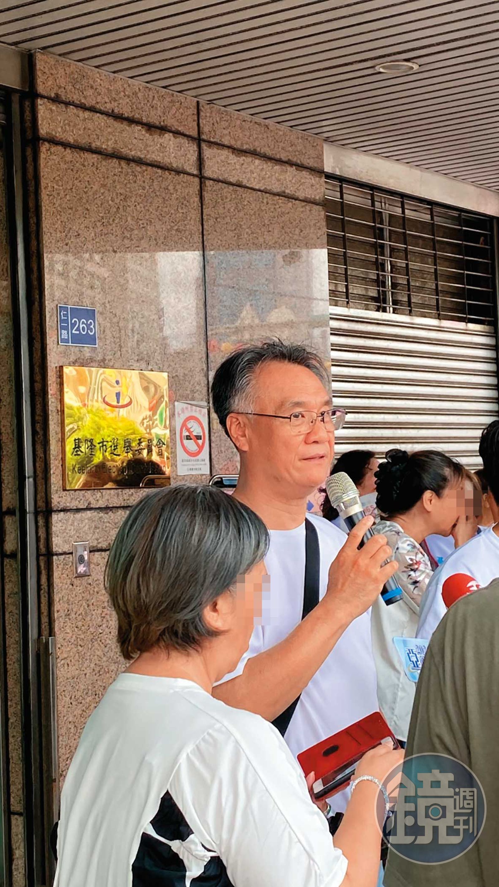 任職於基隆二信的蘇姓公關主任，被拍到手持麥克風，在謝國樑登記現場指揮調度人員。（讀者提供）
