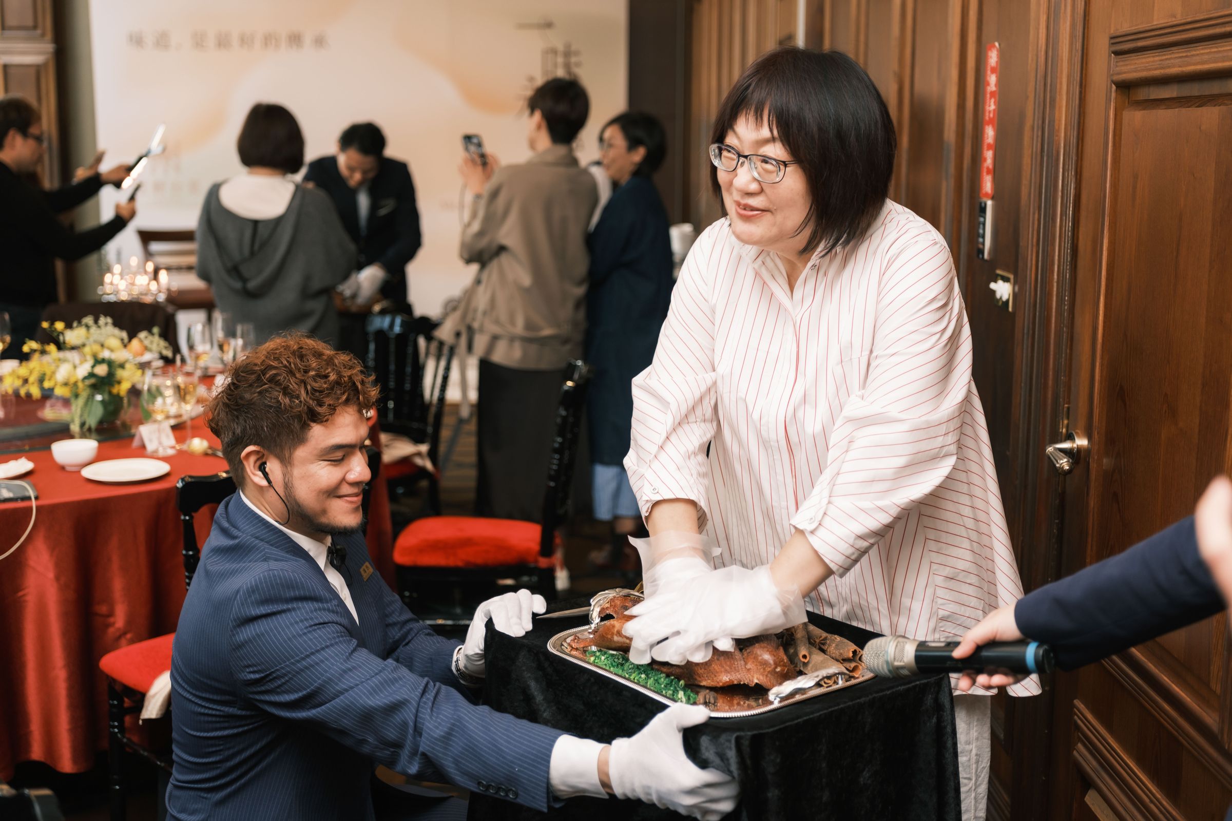 美食家王瑞瑤示範用雙手壓碎鴨骨架，是保師傅這道香酥鴨登場時必要有的儀式。（老新台菜提供）